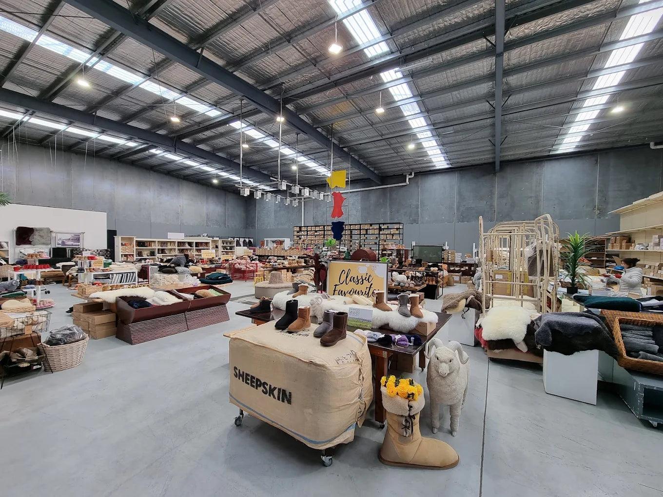 Australian sheepskin boots, rugs, and jackets displayed in a spacious warehouse store.