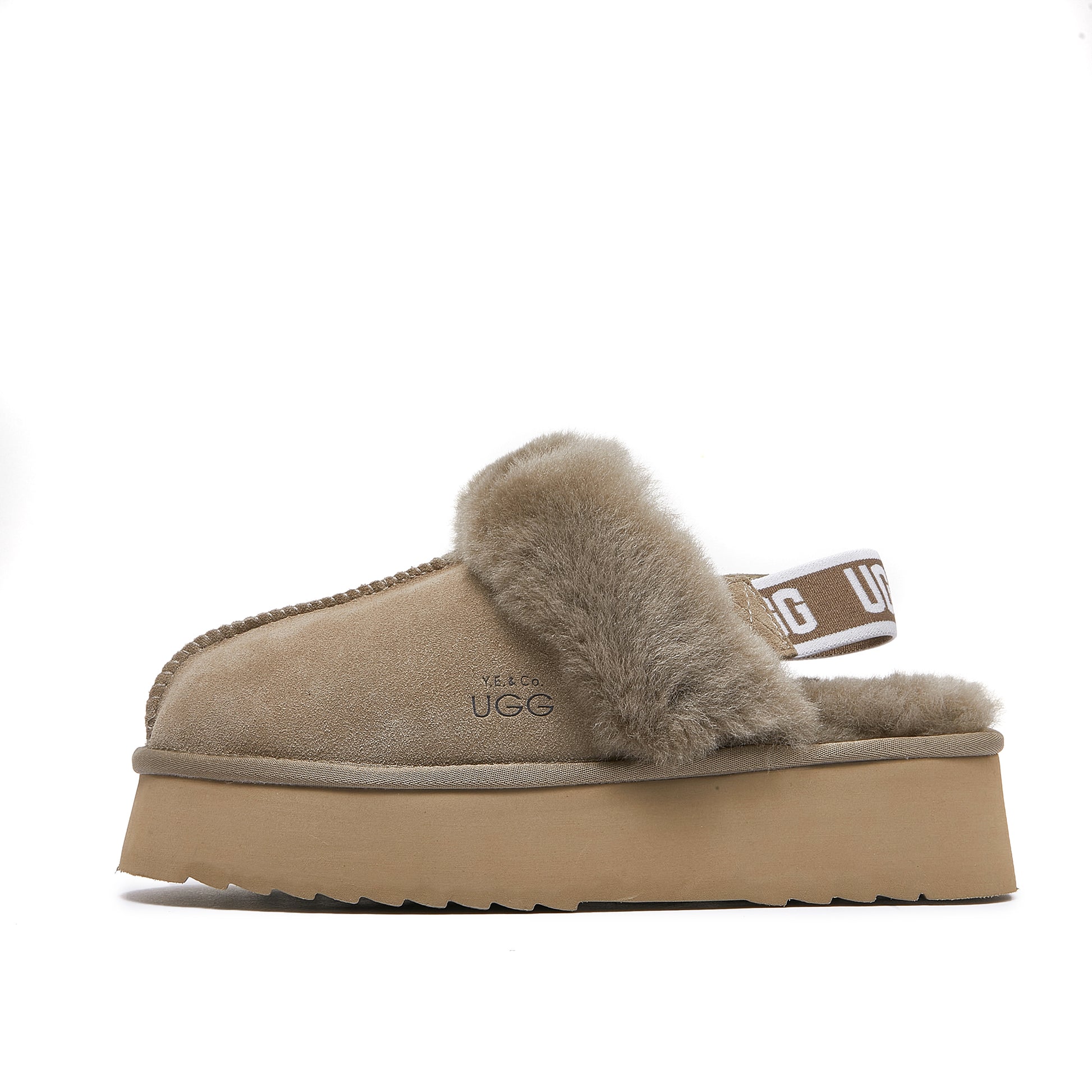 Beige sheepskin UGG platform slipper with fluffy lining and elastic back strap on white background