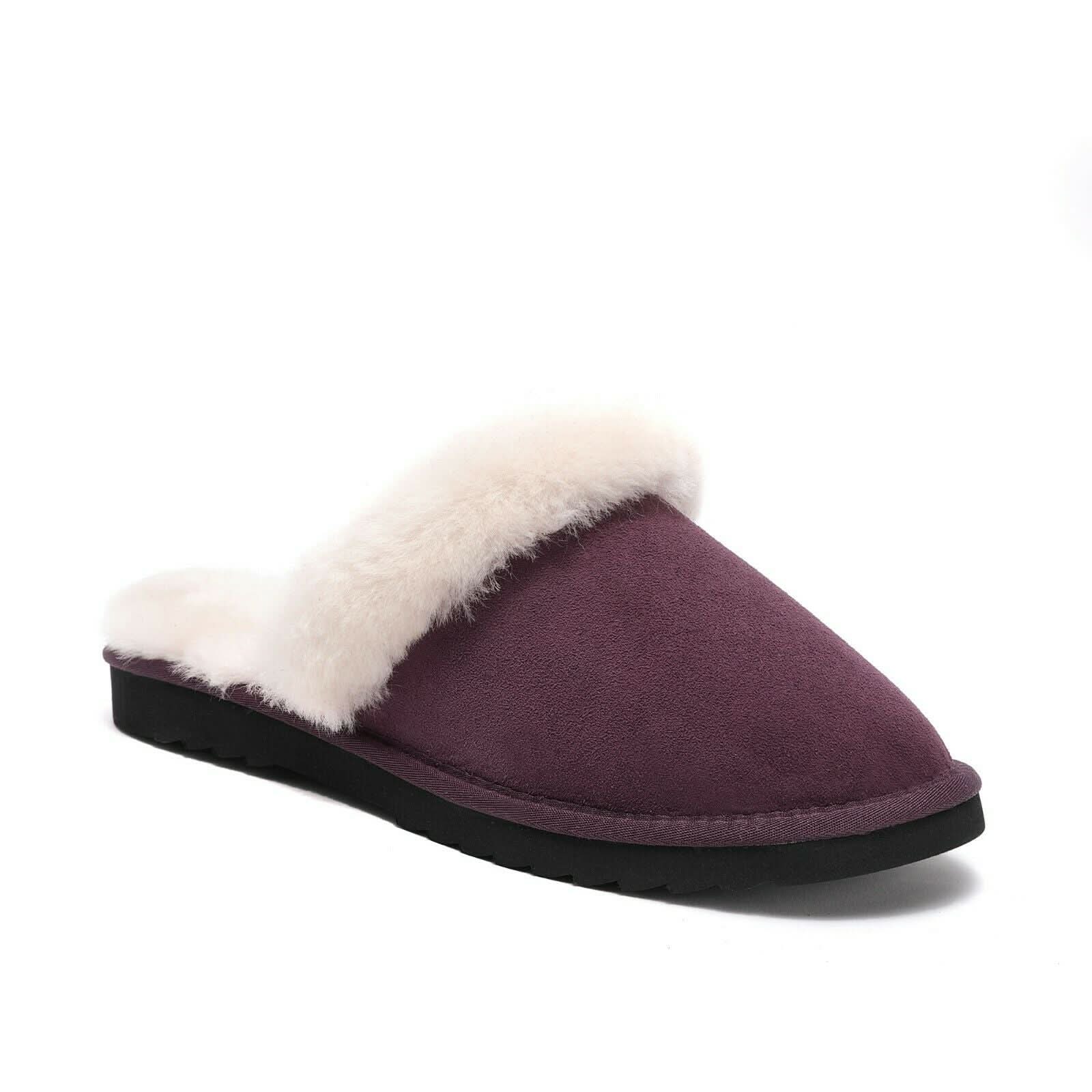 Purple sheepskin slipper with white fluffy lining and black sole on white background