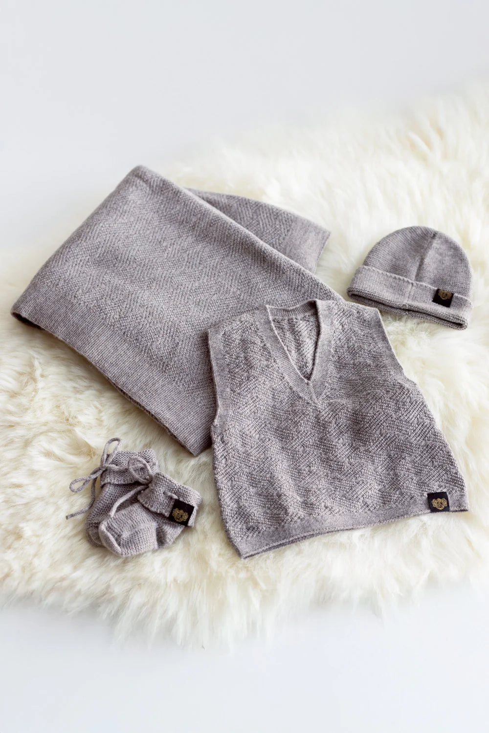 Gray baby outfit with blanket, hat, and booties on a white fur surface - Newborn Baby Bundle — 100% Natural Merino Wool, Made in New Zealand