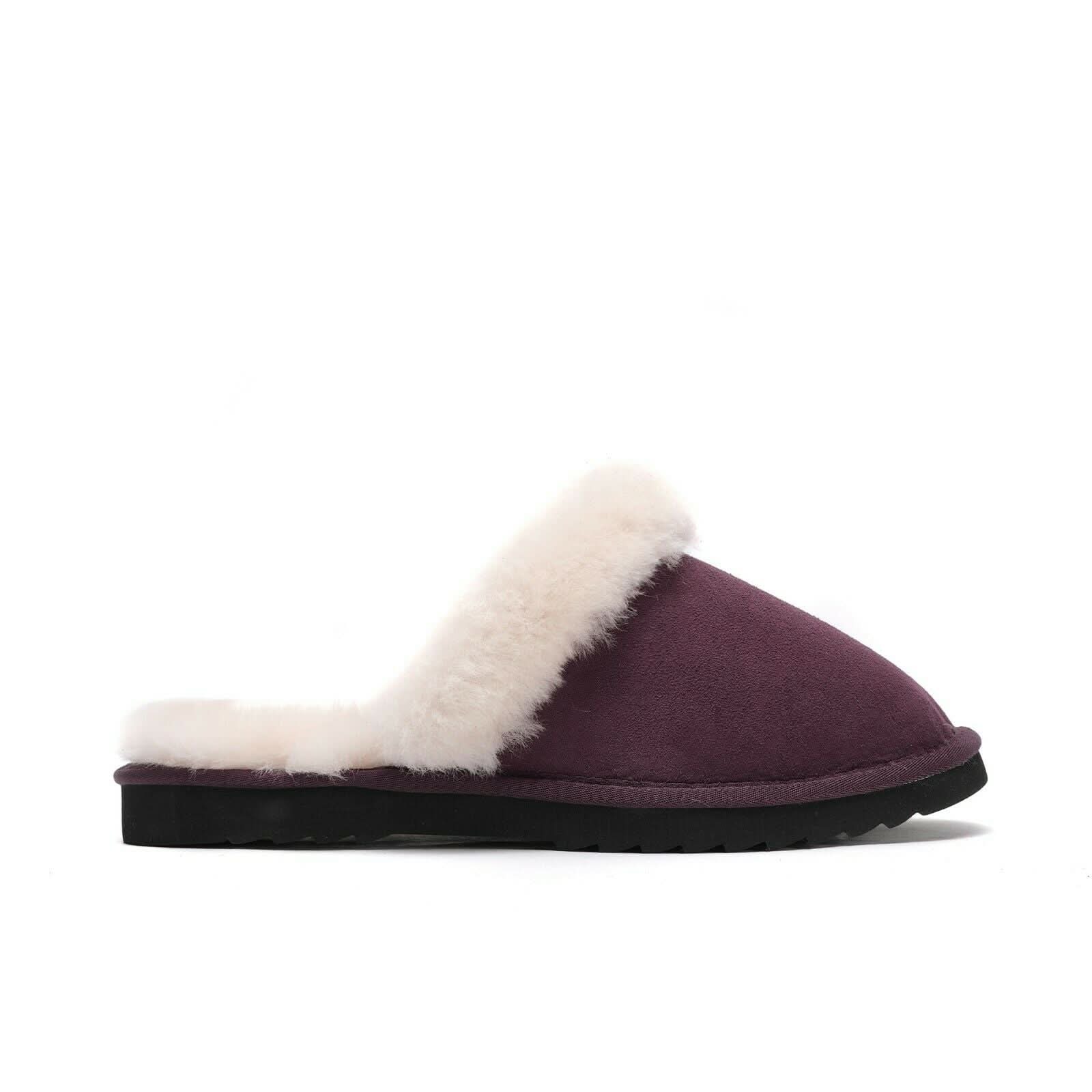 Purple sheepskin slipper with white fleece lining and black sole on white background