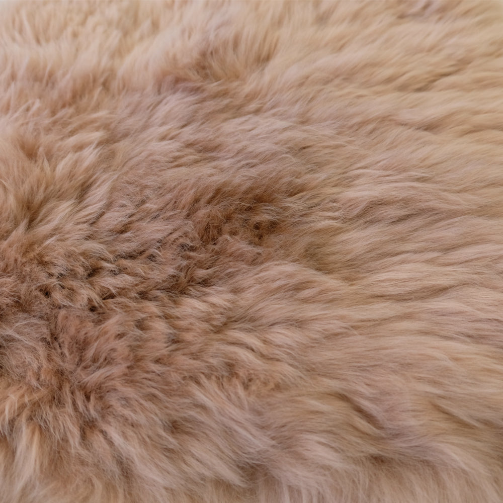 Closeup of soft beige sheepskin rug showing natural wool texture and pile. - Yellow Earth Australia