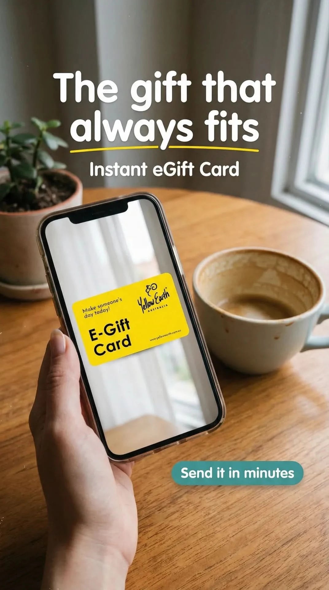 Yellow and white instant digital gift card displayed on smartphone screen on wooden desk. - Yellow Earth Australia