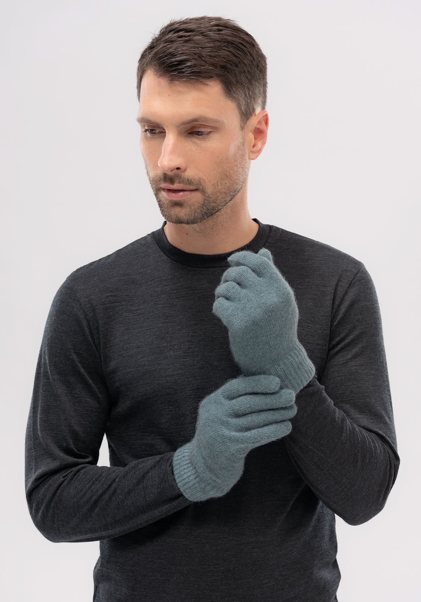 Grey wool gloves displayed on model wearing charcoal sweater, frontal view. - Yellow Earth Australia