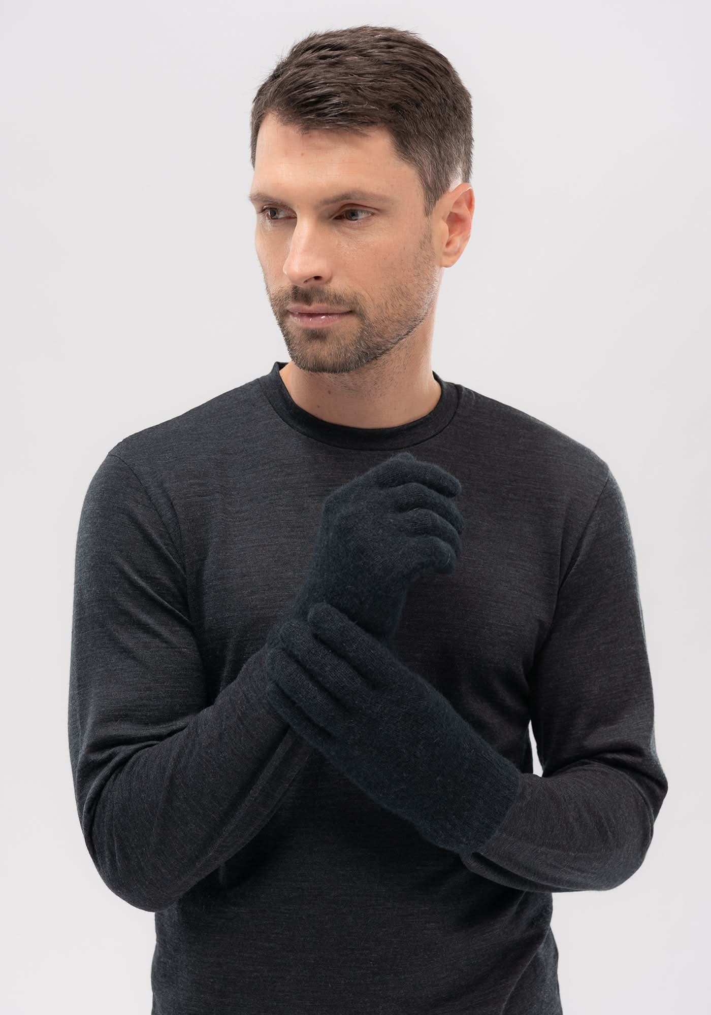 Dark grey merino wool gloves crossed on man's chest in front view. - Yellow Earth Australia