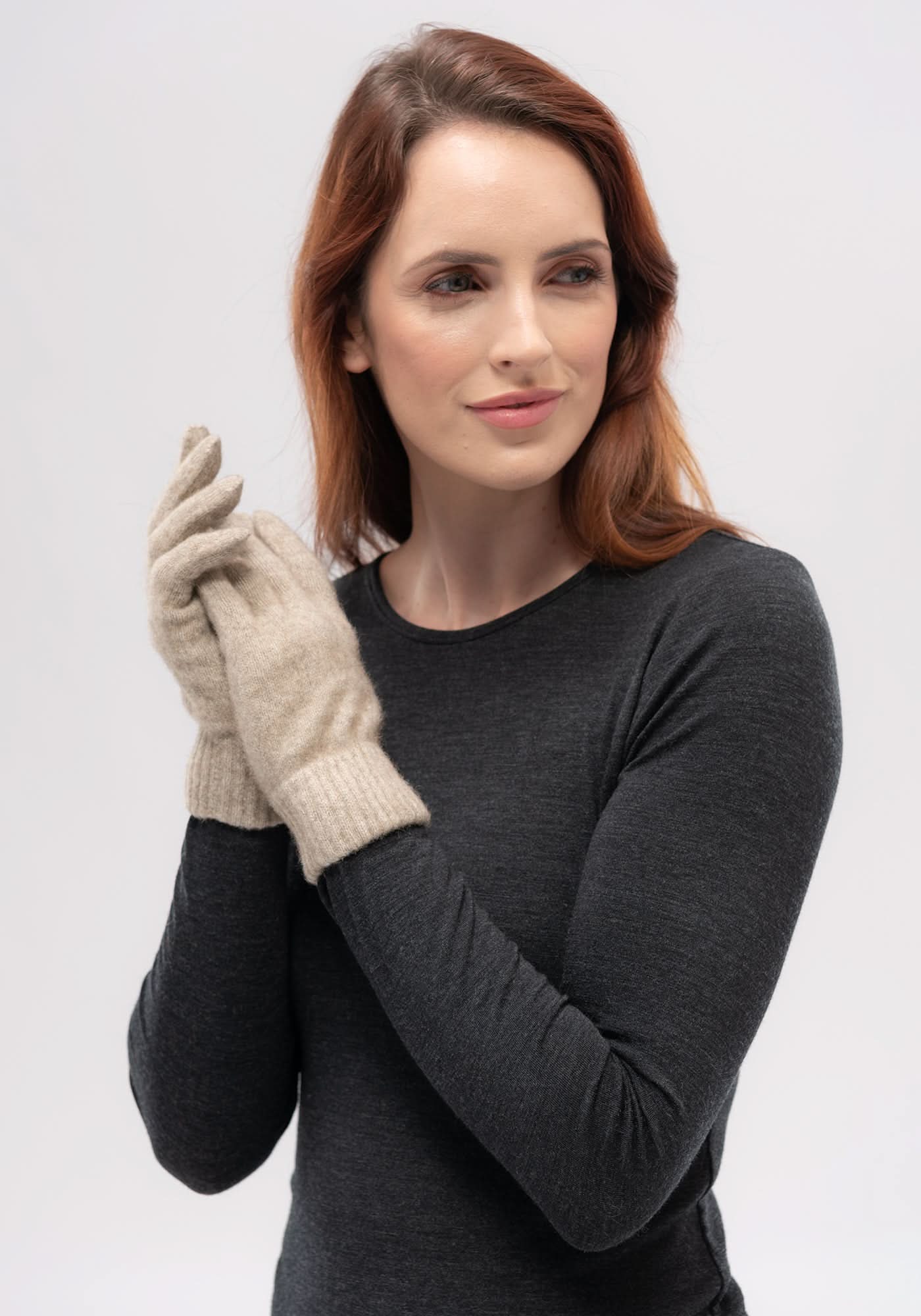 Woman wearing beige wool gloves with charcoal sweater, front view. - Yellow Earth Australia