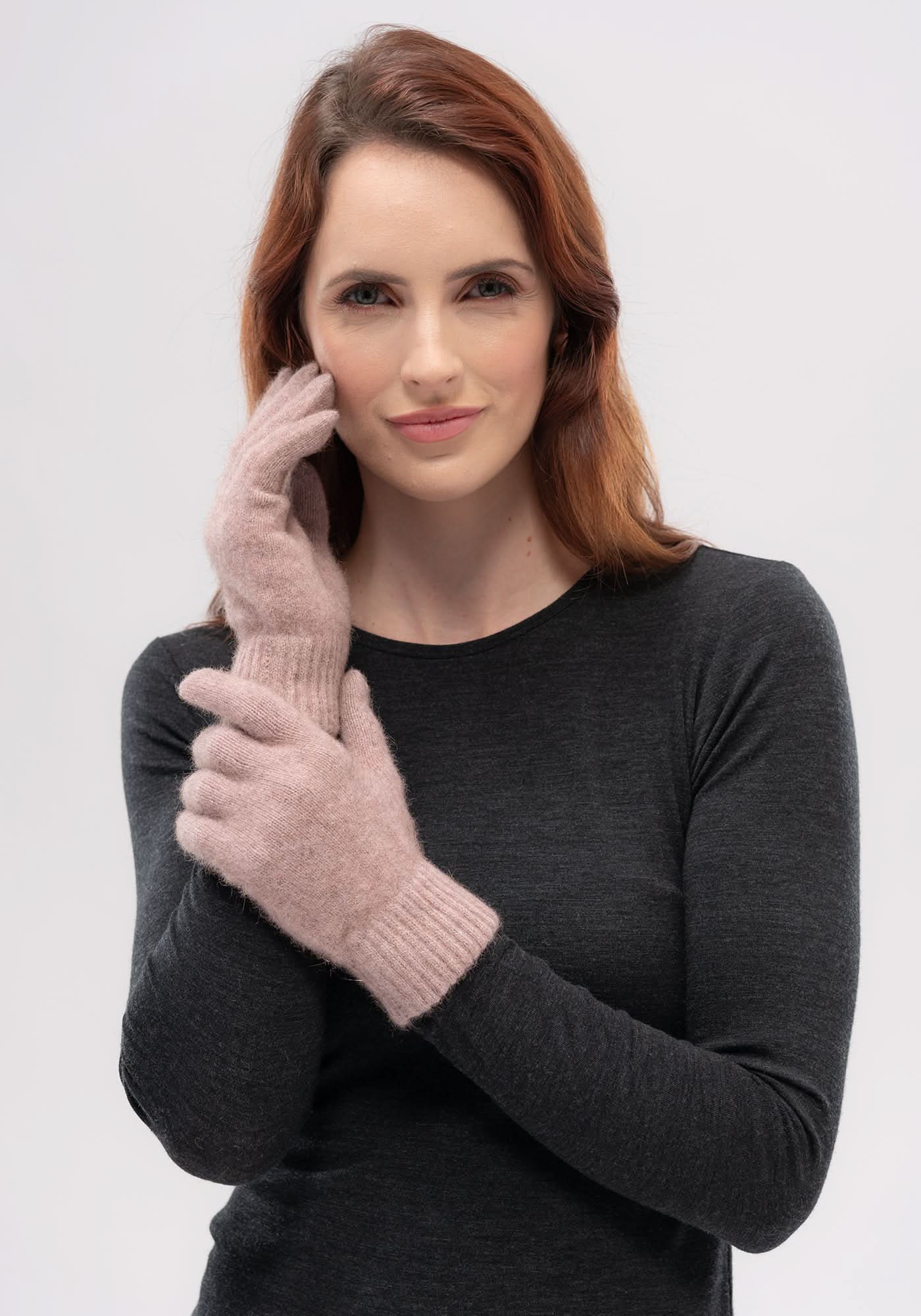 Woman wearing pink wool gloves with charcoal long-sleeve top, front view. - Yellow Earth Australia
