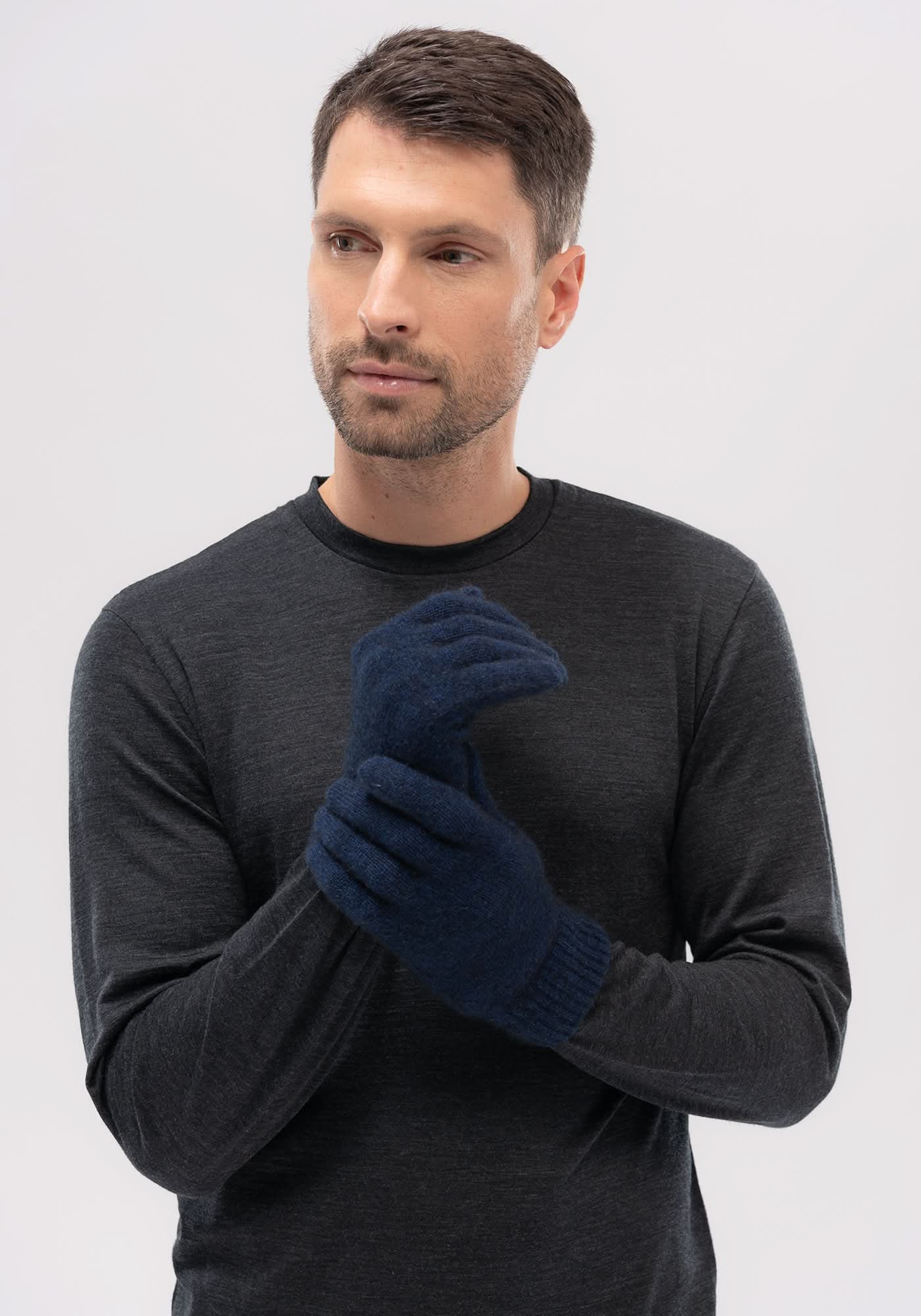 Navy wool gloves displayed on male model wearing charcoal sweater against white background. - Yellow Earth Australia