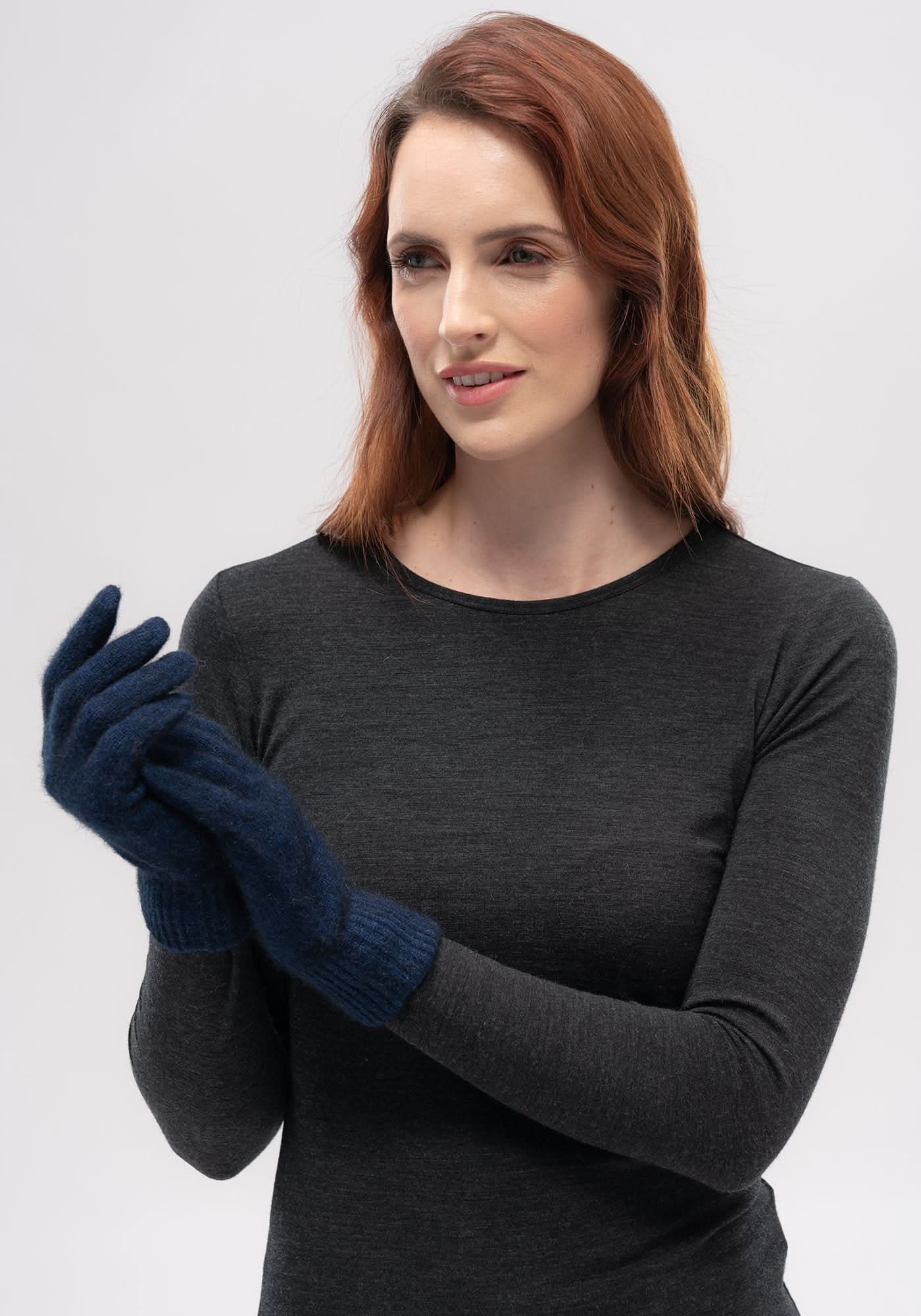 Woman wearing dark grey merino wool long-sleeve top with navy knit wool gloves, front view. - Yellow Earth Australia