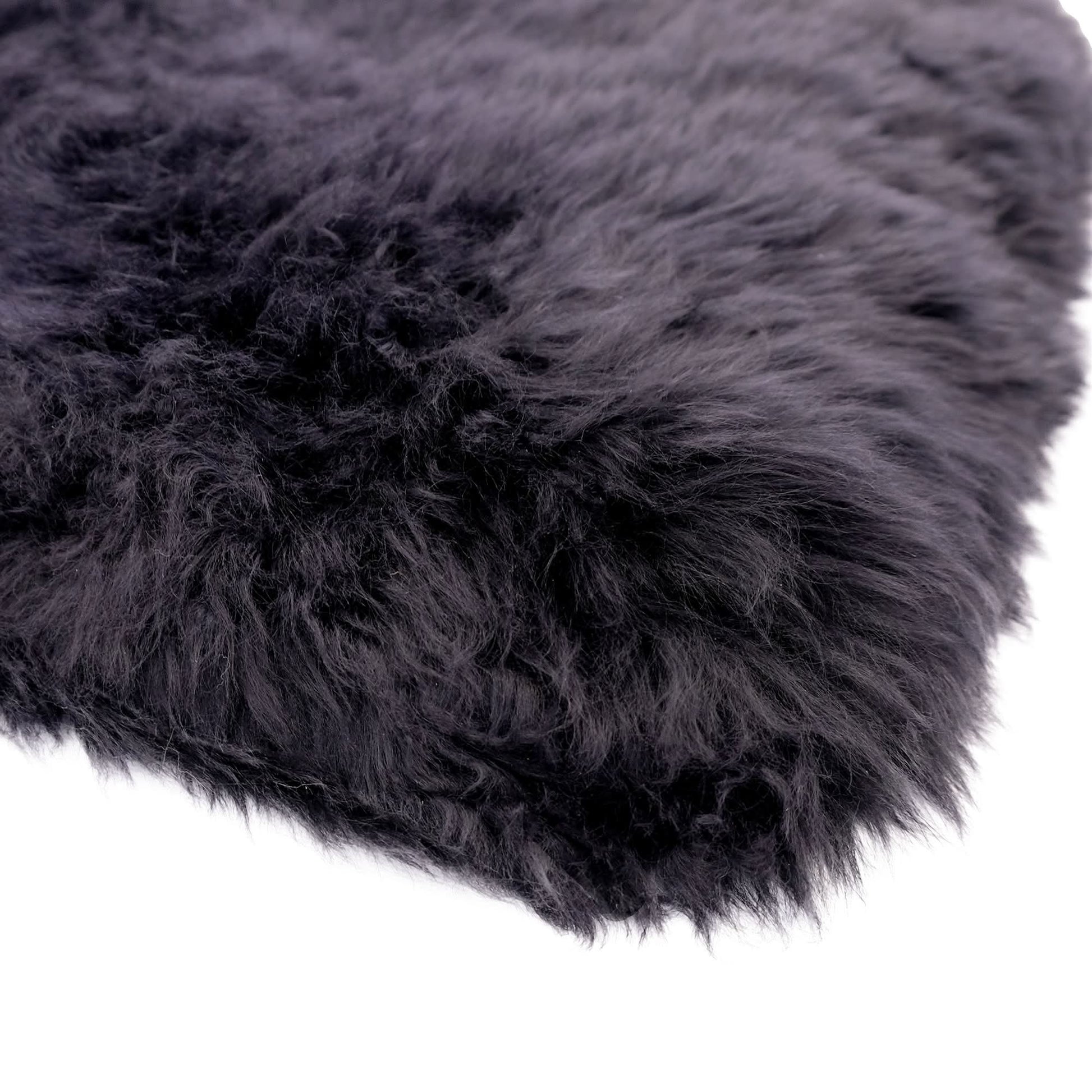 Black sheepskin rug with thick wool pile viewed from above corner angle. - Yellow Earth Australia