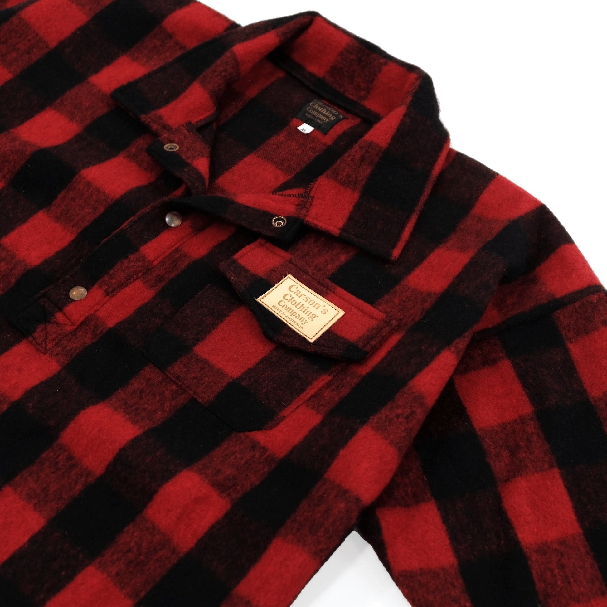 Red and black buffalo check wool flannel shirt folded flat lay view with visible label. - Yellow Earth Australia