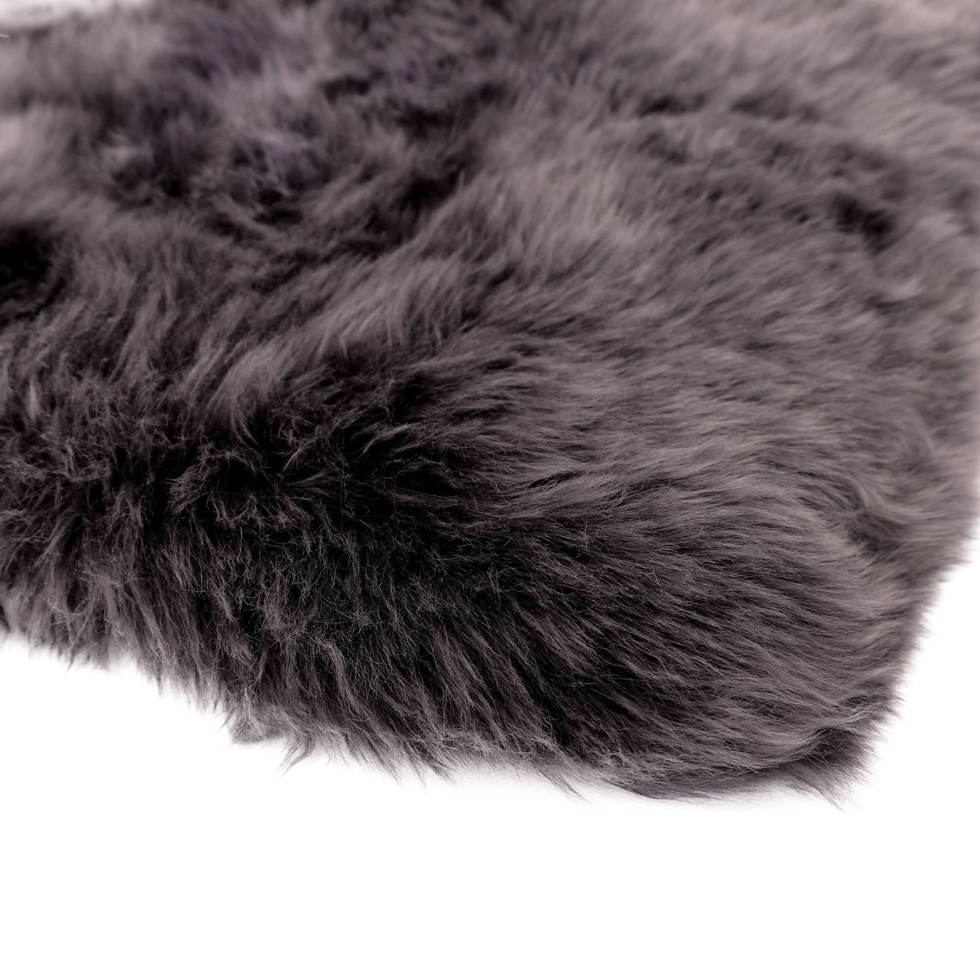 Dark grey sheepskin rug with soft wool texture, top-down angled view on white background. - Yellow Earth Australia
