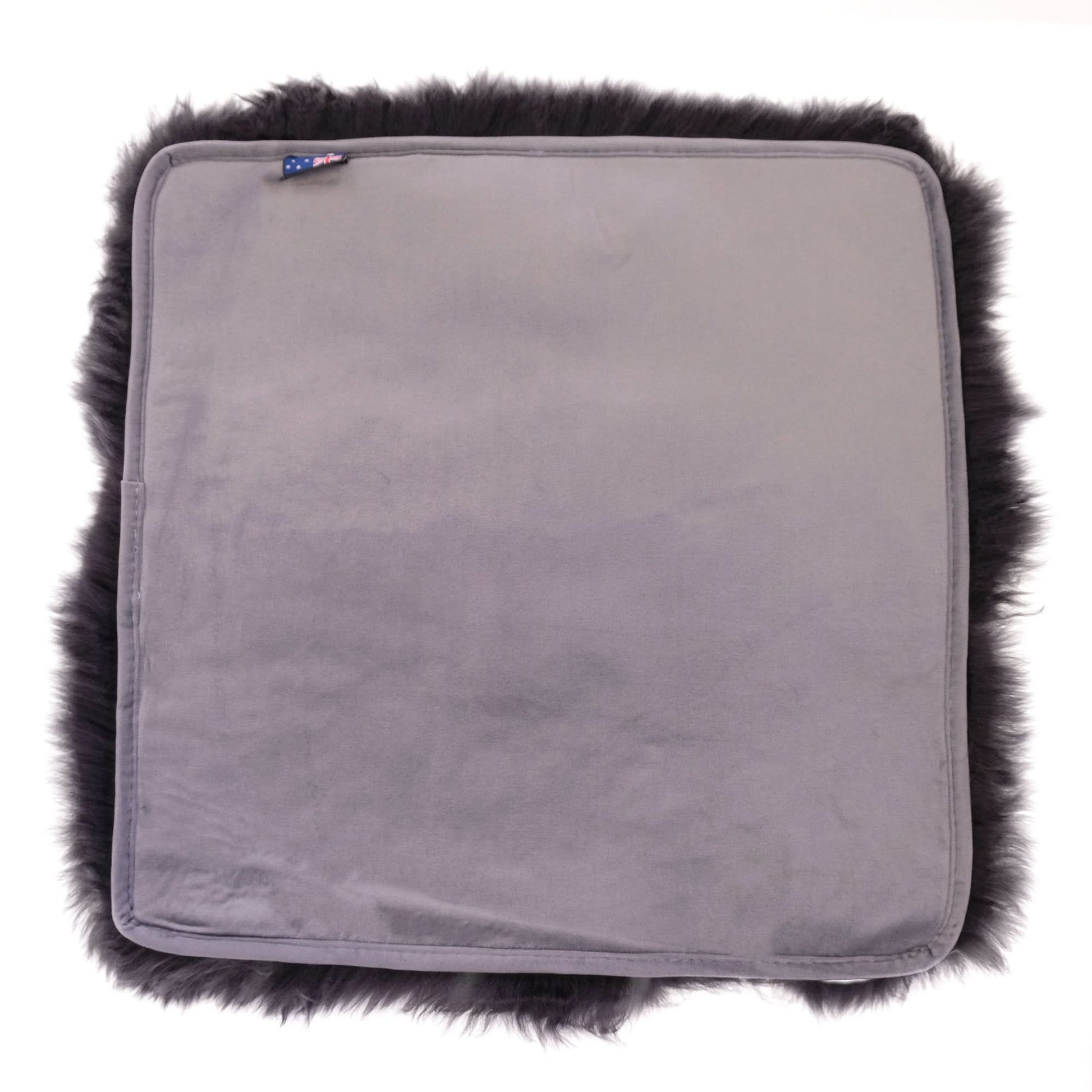 Grey sheepskin seat cushion with black fur trim, top view. - Yellow Earth Australia