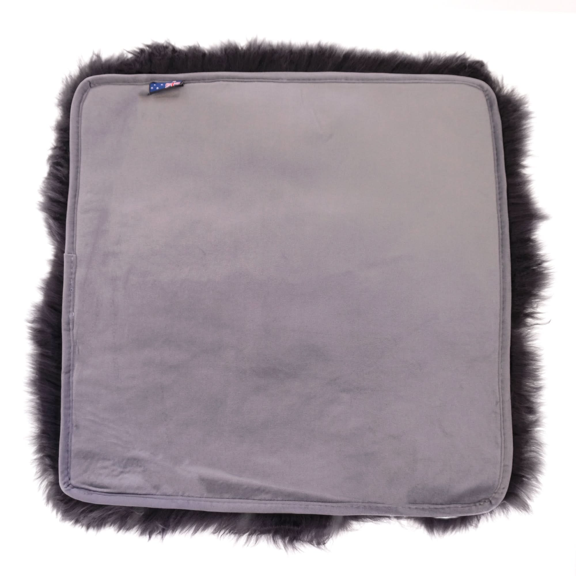 Grey sheepskin seat cushion with black fur trim, top view. - Yellow Earth Australia