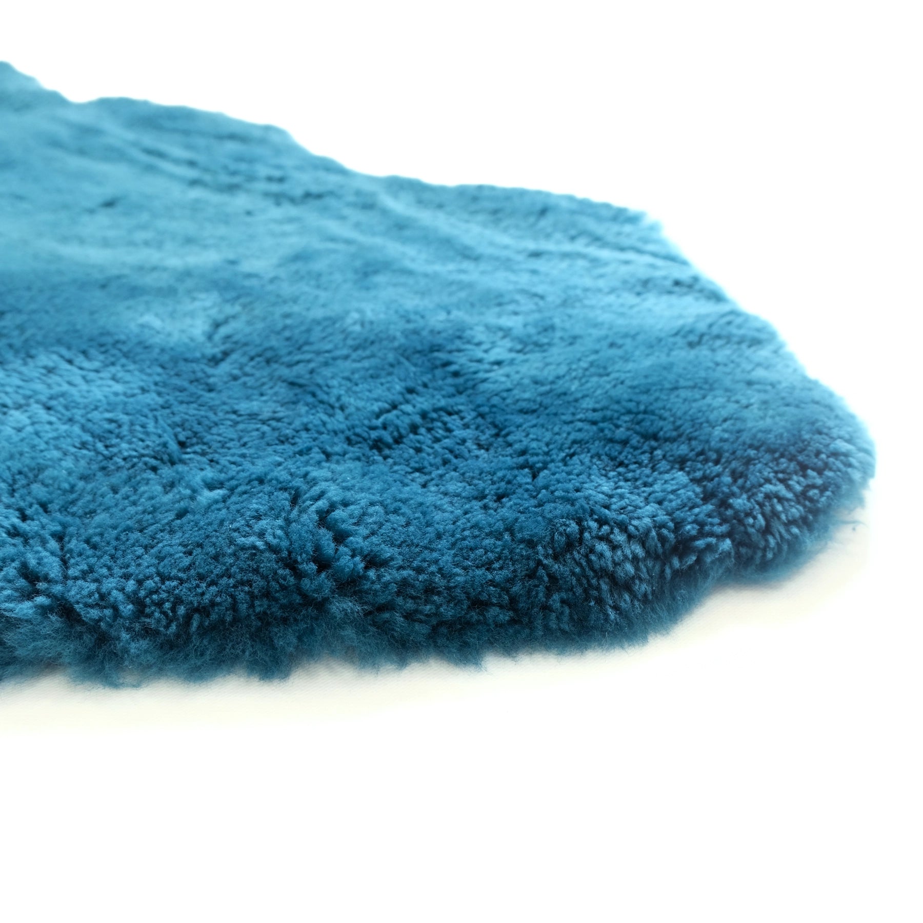 Teal blue sheepskin rug with soft wool texture shown from above angle. - Yellow Earth Australia