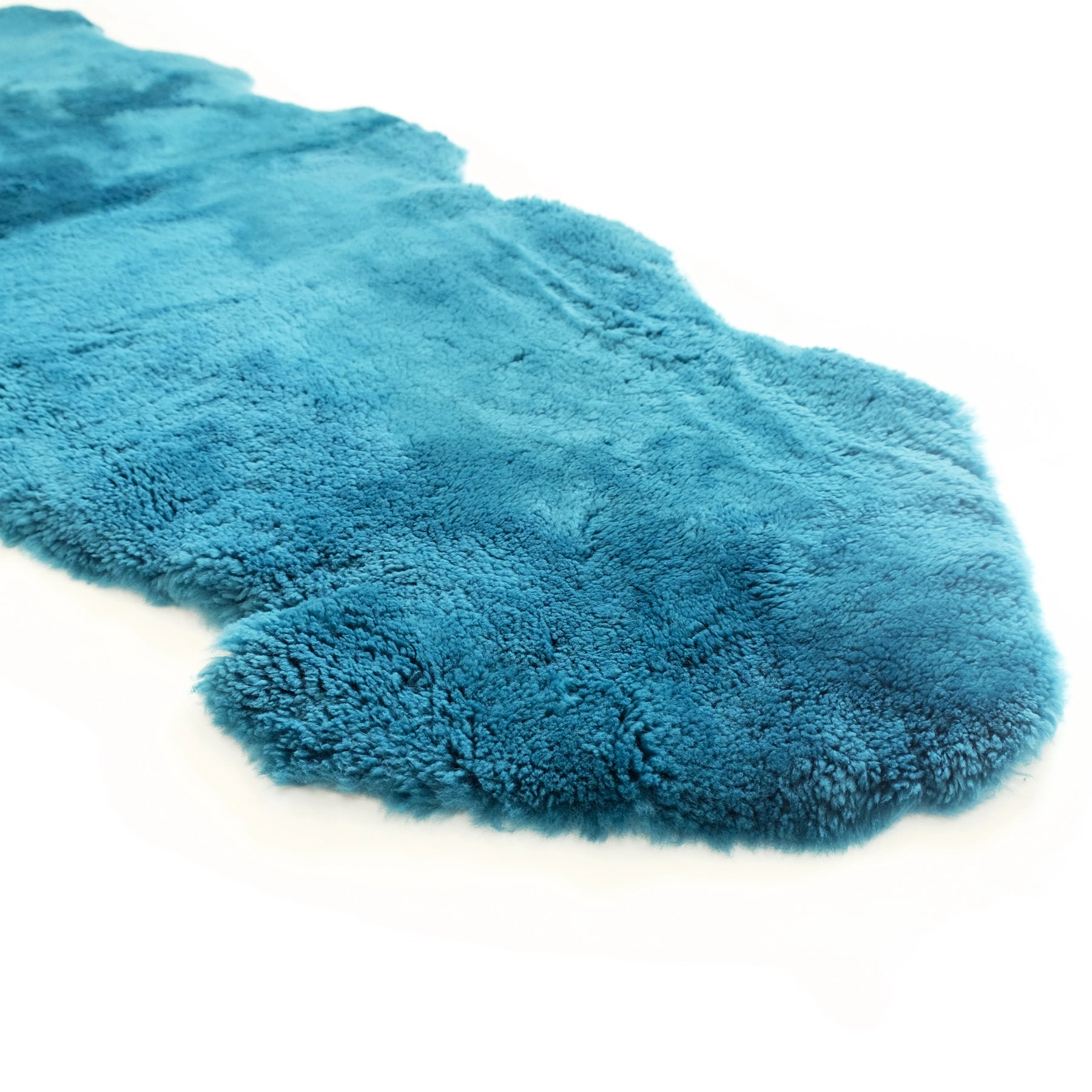 Turquoise sheepskin rug with soft wool pile shown from above on white background. - Yellow Earth Australia