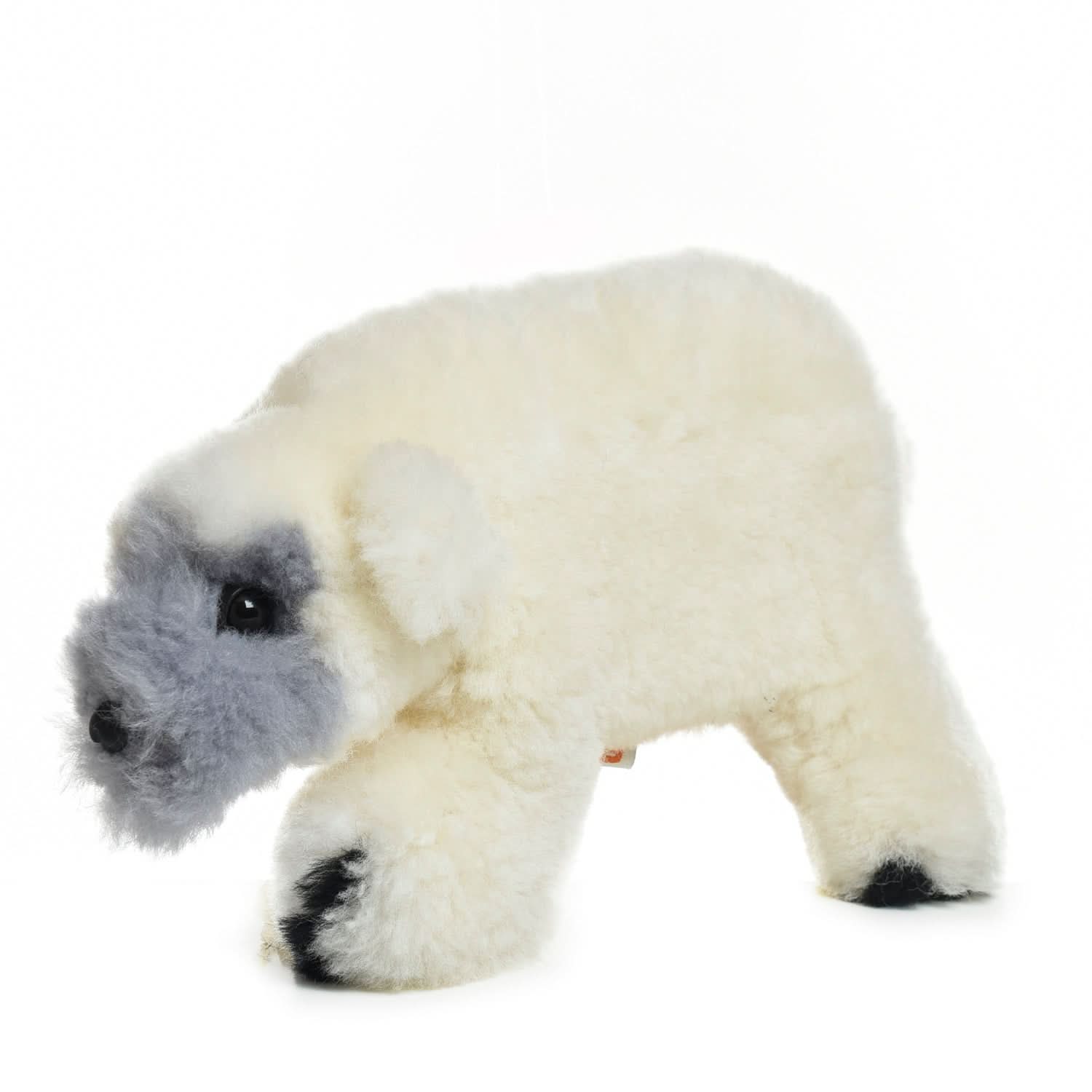 Plush white sheepskin polar bear toy with gray face and black paw pads, side view. - Yellow Earth Australia