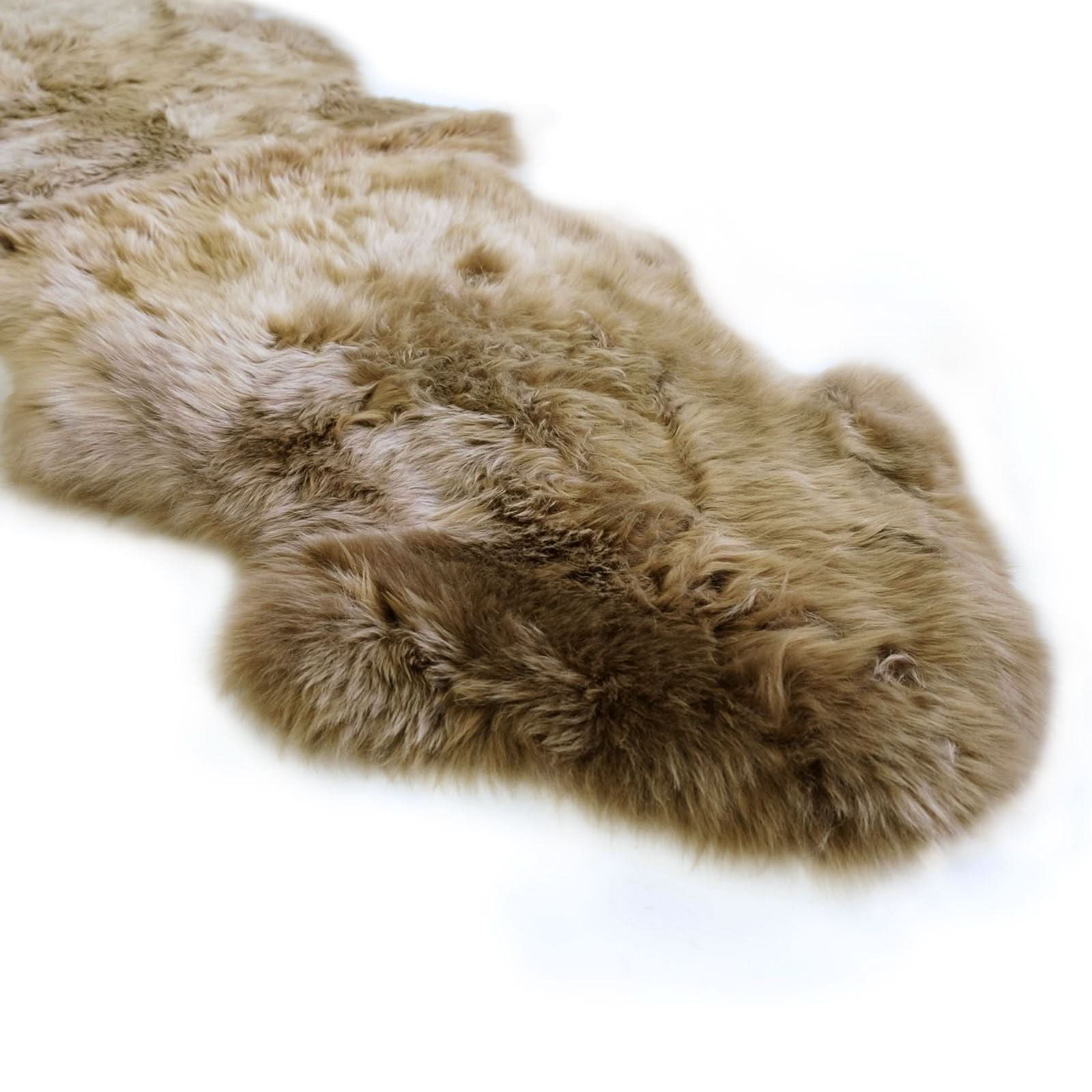 Natural sheepskin rug with thick cream and tan wool viewed from above on white background. - Yellow Earth Australia