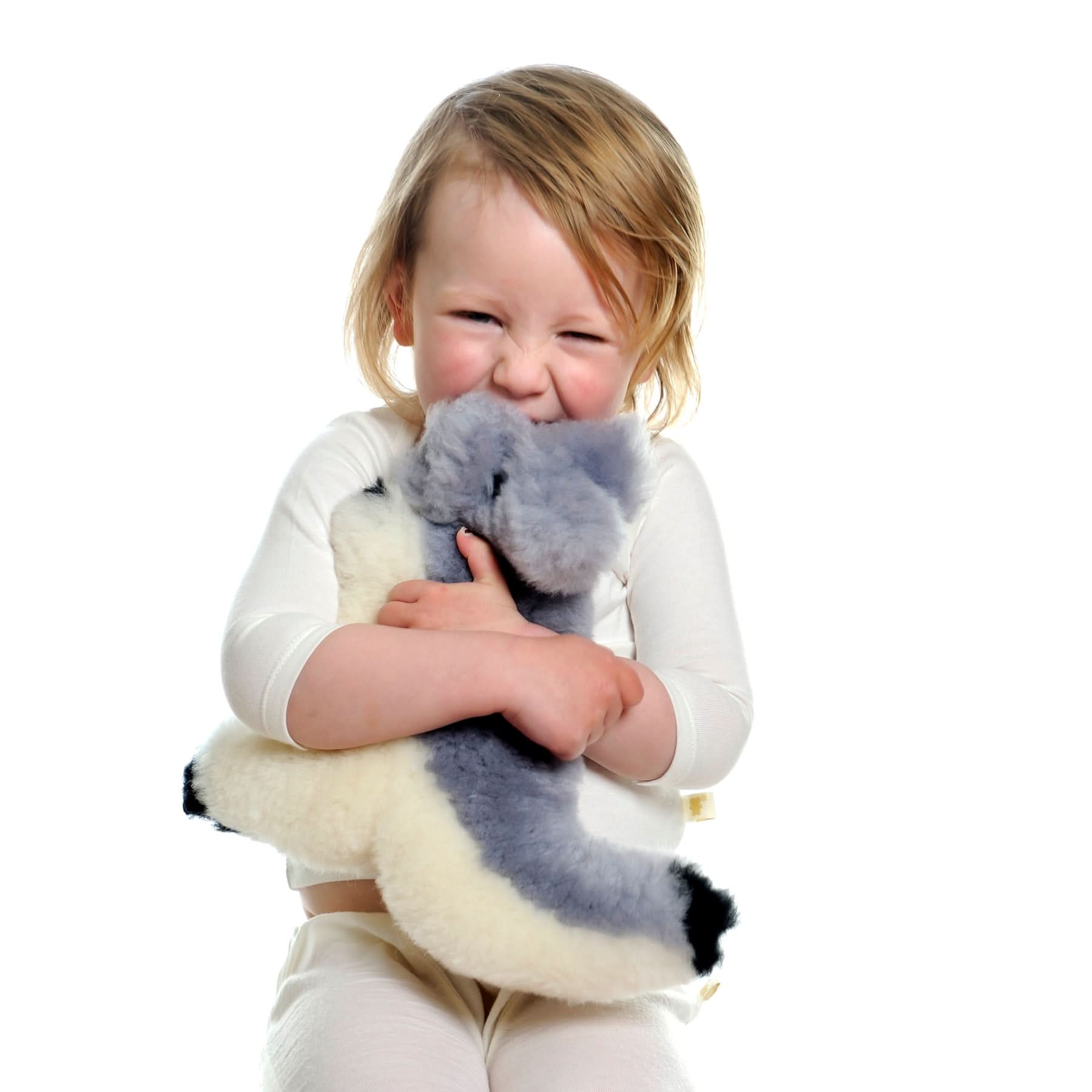 Toddler hugging grey and white sheepskin koala plush toy against white background. - Yellow Earth Australia