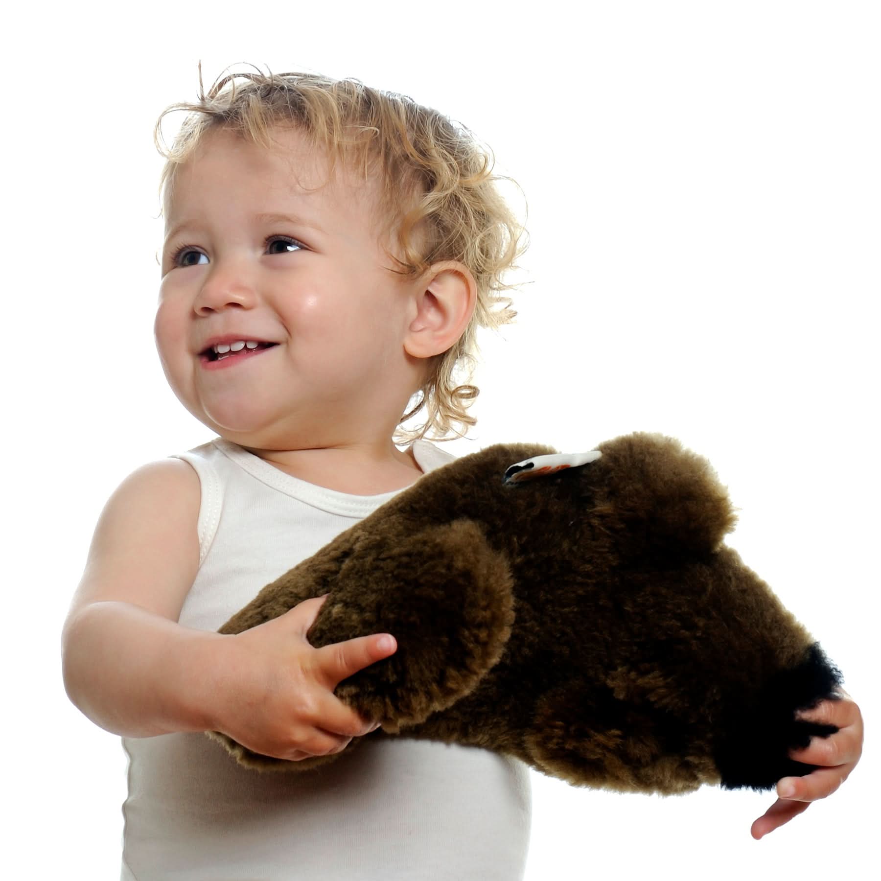 Toddler holding soft brown sheepskin wool product against white background. - Yellow Earth Australia
