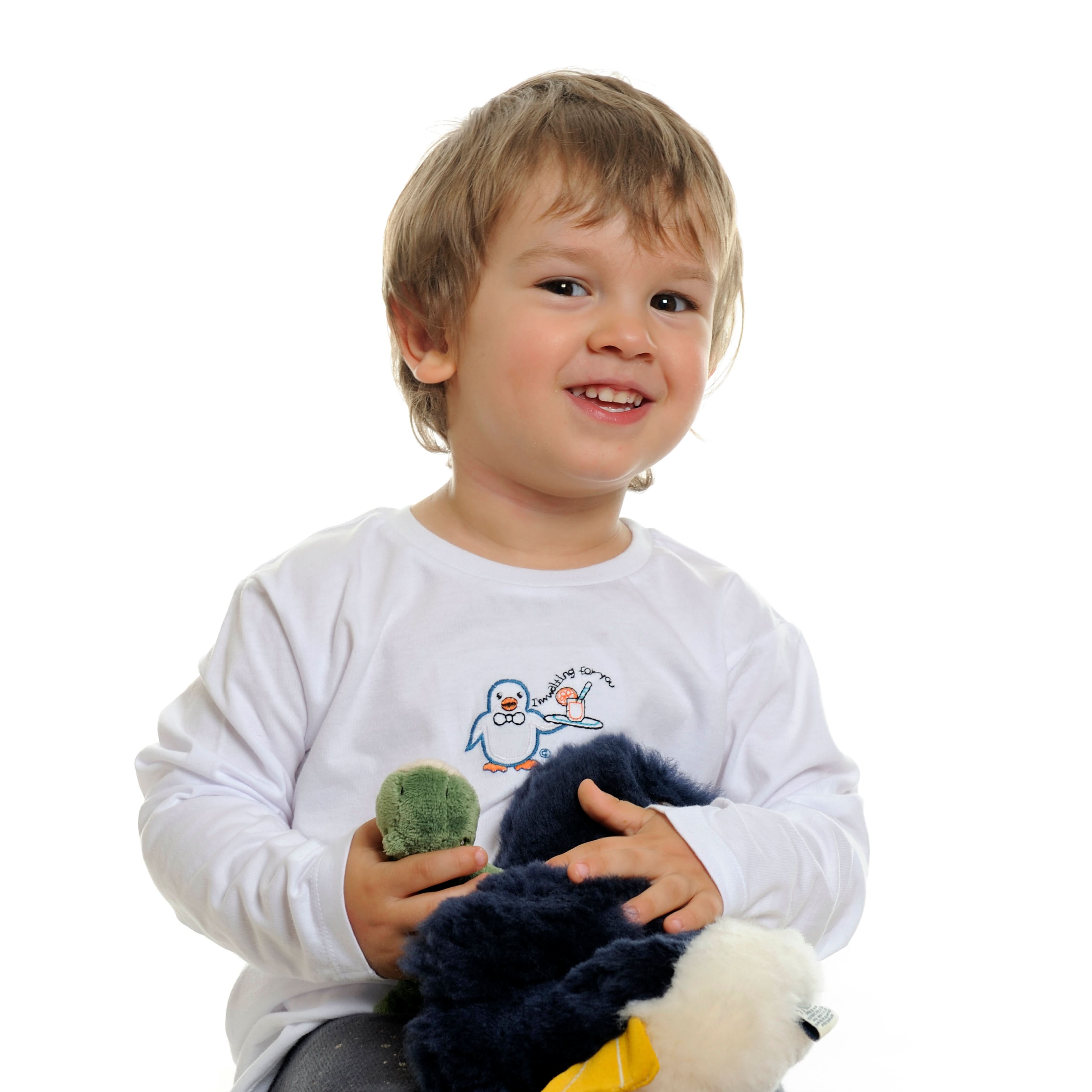 Toddler holding soft navy sheepskin toy with white trim and green moss ball accessory. - Yellow Earth Australia