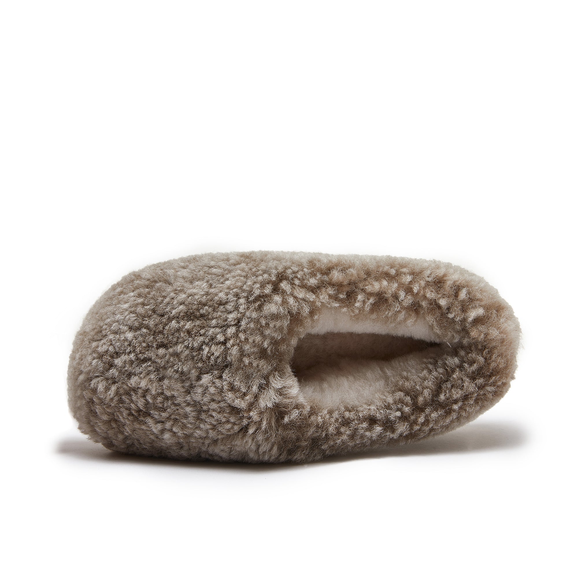 Beige sheepskin slipper with fluffy wool texture, side view on white background. - Yellow Earth Australia