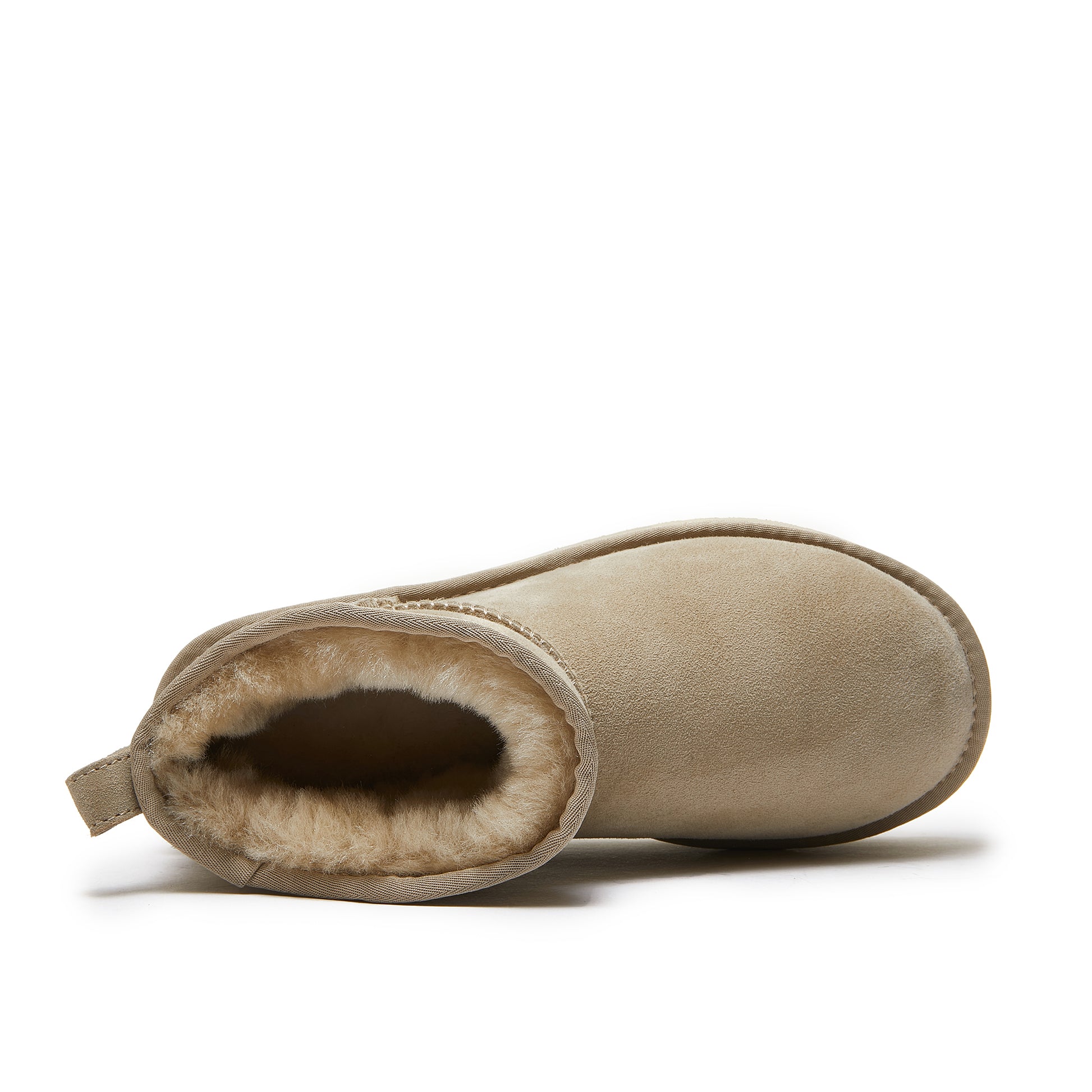 Top view of a tan sheepskin UGG boot with plush wool lining on a white background.