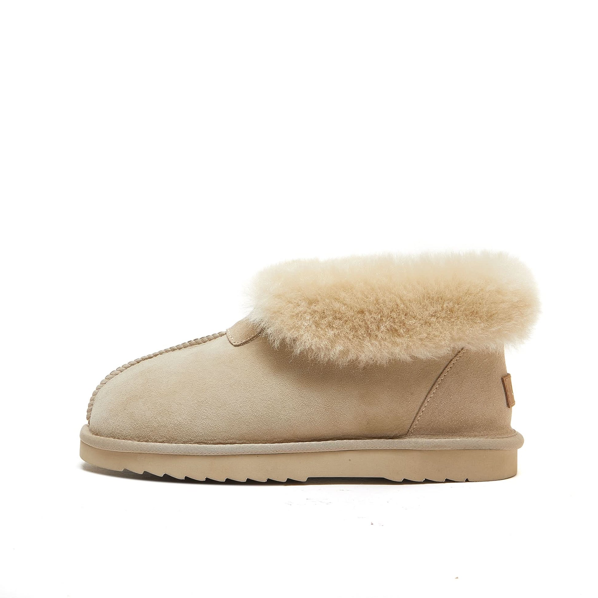 Beige sheepskin ankle boot with plush wool collar and rubber sole on white background