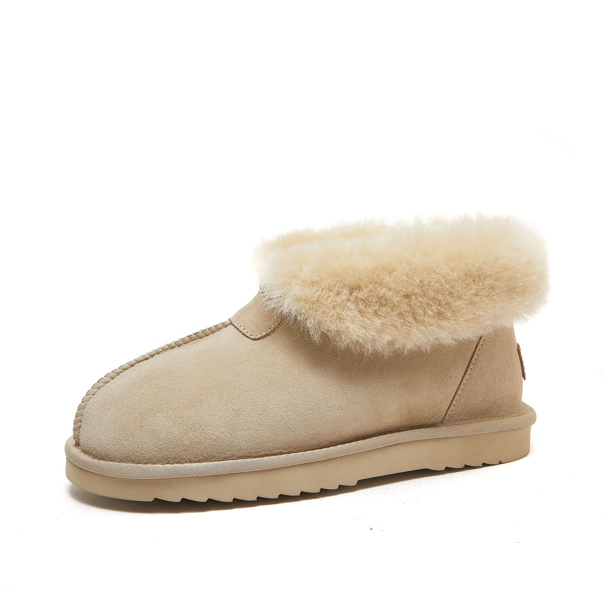Beige sheepskin UGG boot with plush wool lining and suede exterior on white background.