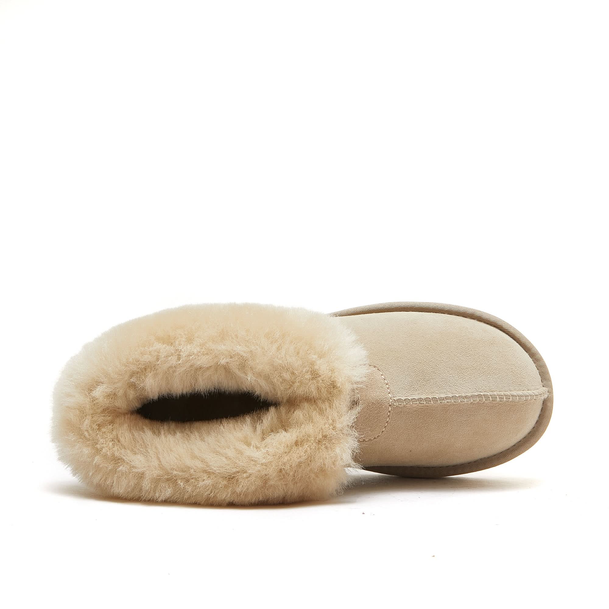 Top view of a beige sheepskin UGG boot with soft wool lining on a white background