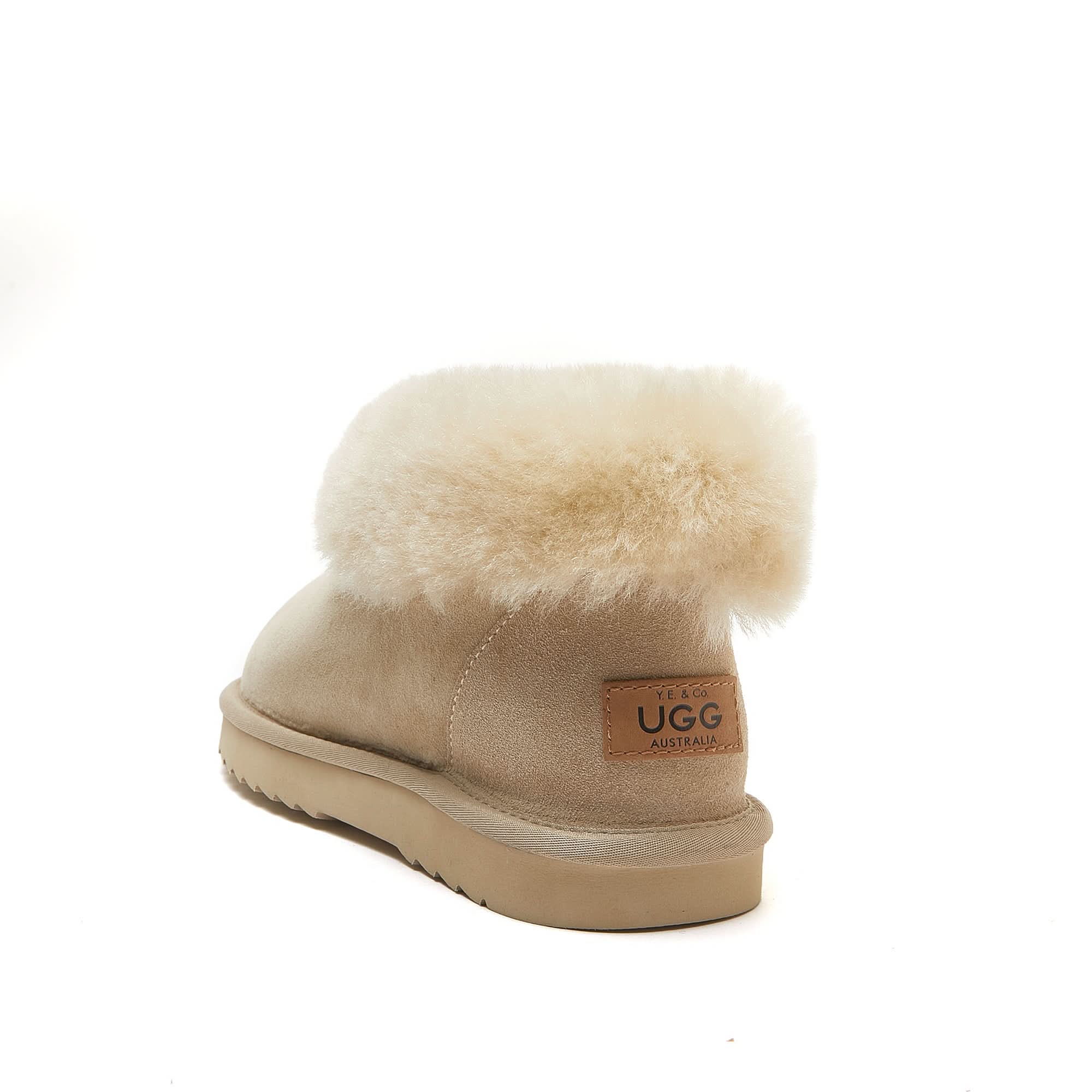 Beige sheepskin UGG boot with plush wool cuff on white background