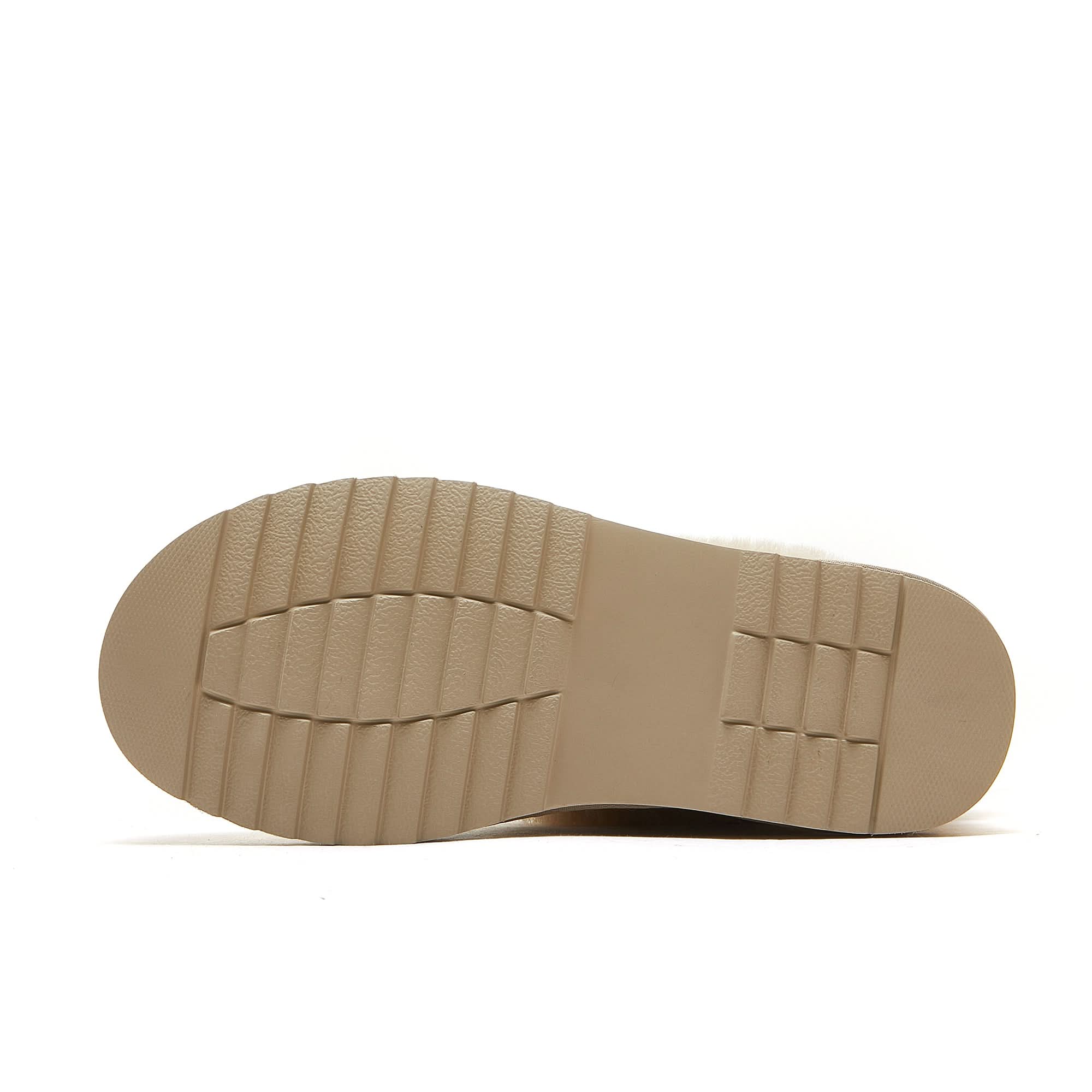 Beige textured rubber sole of a sheepskin UGG boot on white background
