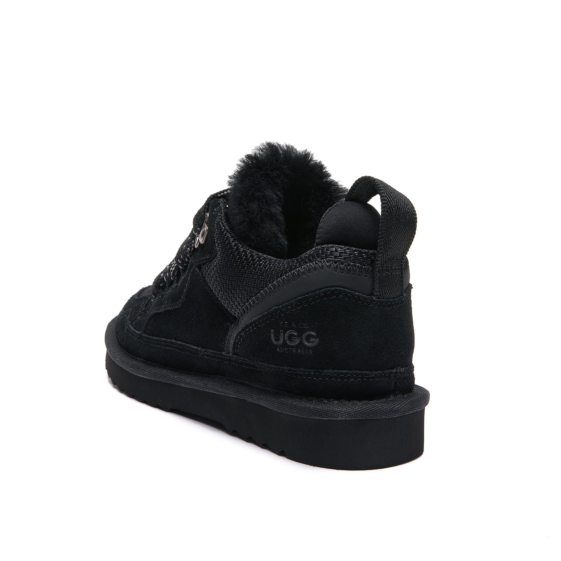 Leslie Chunky Sheepskin-Lined Sneaker in Black - A black Ugg mid-top sneaker with a plush fwool collar, shown from a rear three-quarter angle on a white background.