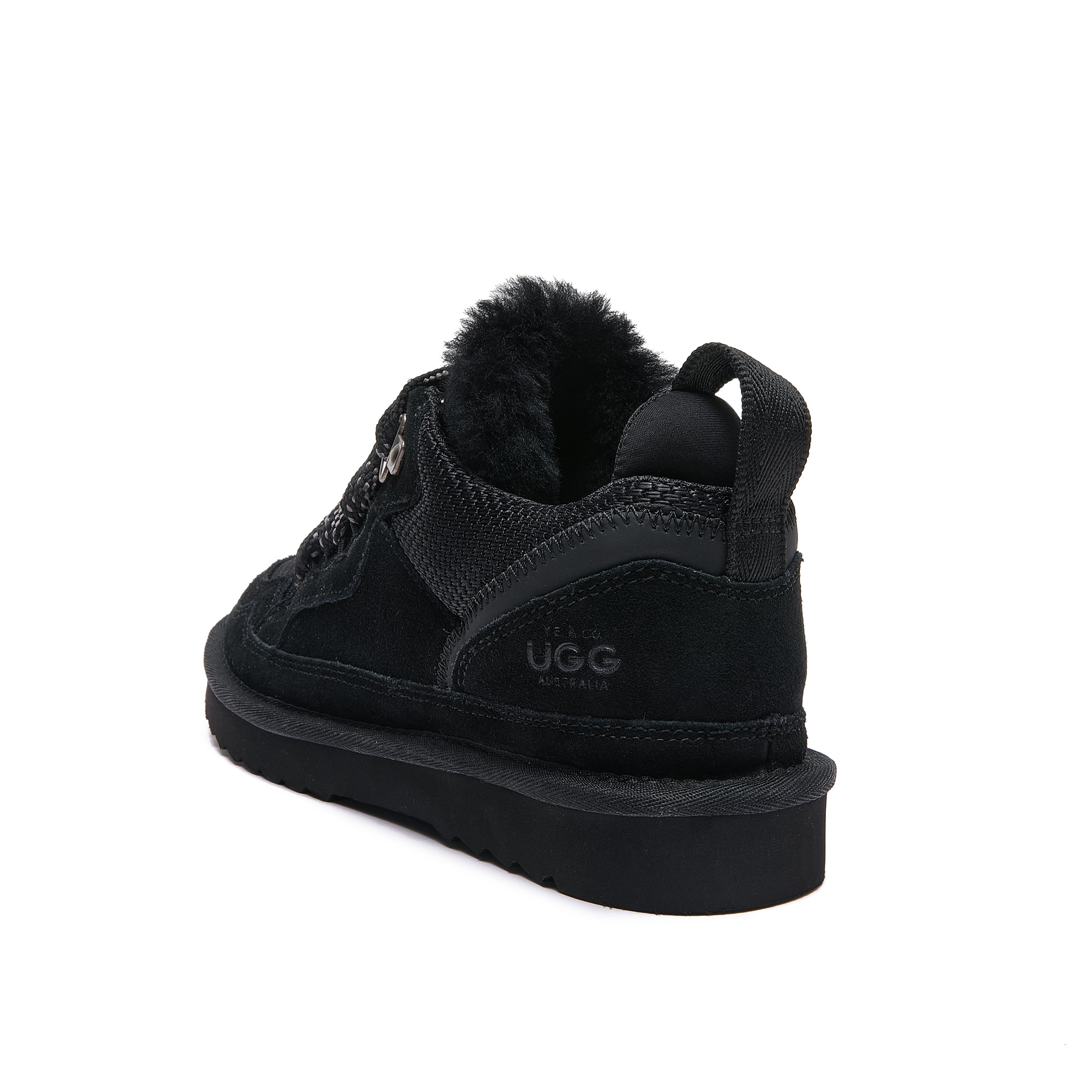 Leslie Chunky Sheepskin-Lined Sneaker in Black - A black Ugg mid-top sneaker with a plush fwool collar, shown from a rear three-quarter angle on a white background.