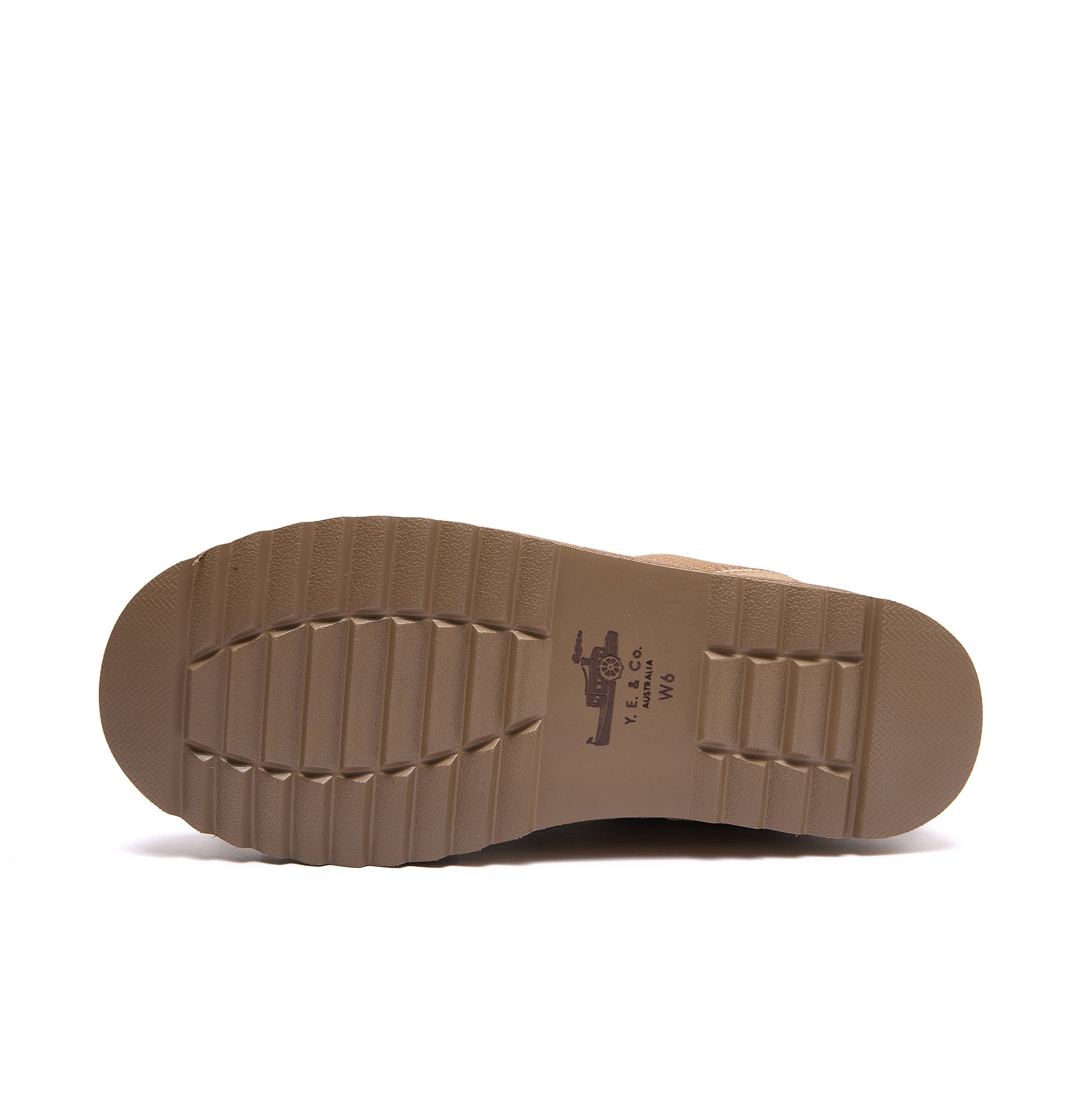 Leslie Chunky Sheepskin-Lined Sneaker in Chestnut - The outsole of a brown boot or shoe, showing a textured tread pattern and a small printed logo in the center, photographed against a solid white background.