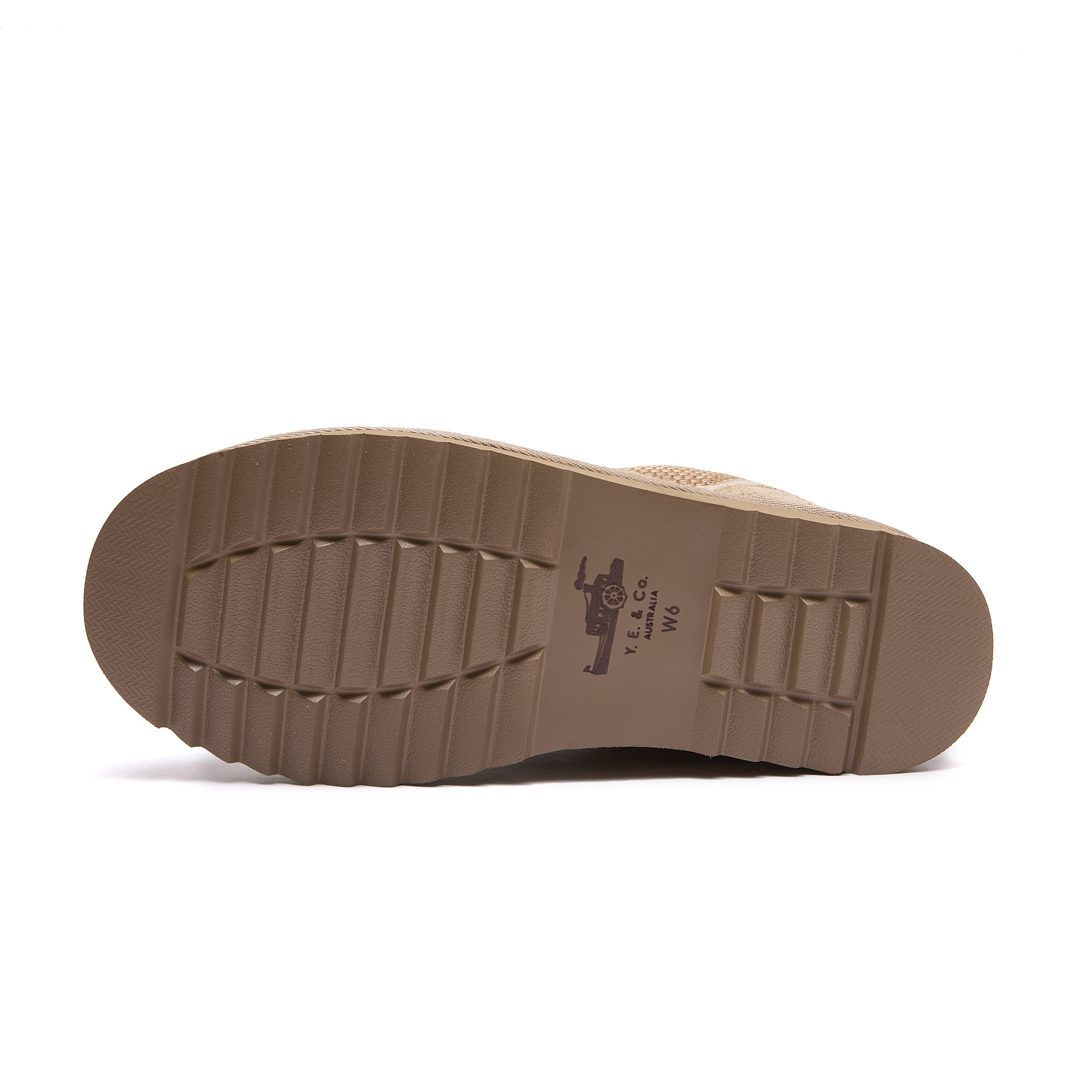 Leslie Chunky Sheepskin-Lined Sneaker in Sand - The outsole of a tan boot, showing a textured tread pattern and a small printed logo, on a plain white background.