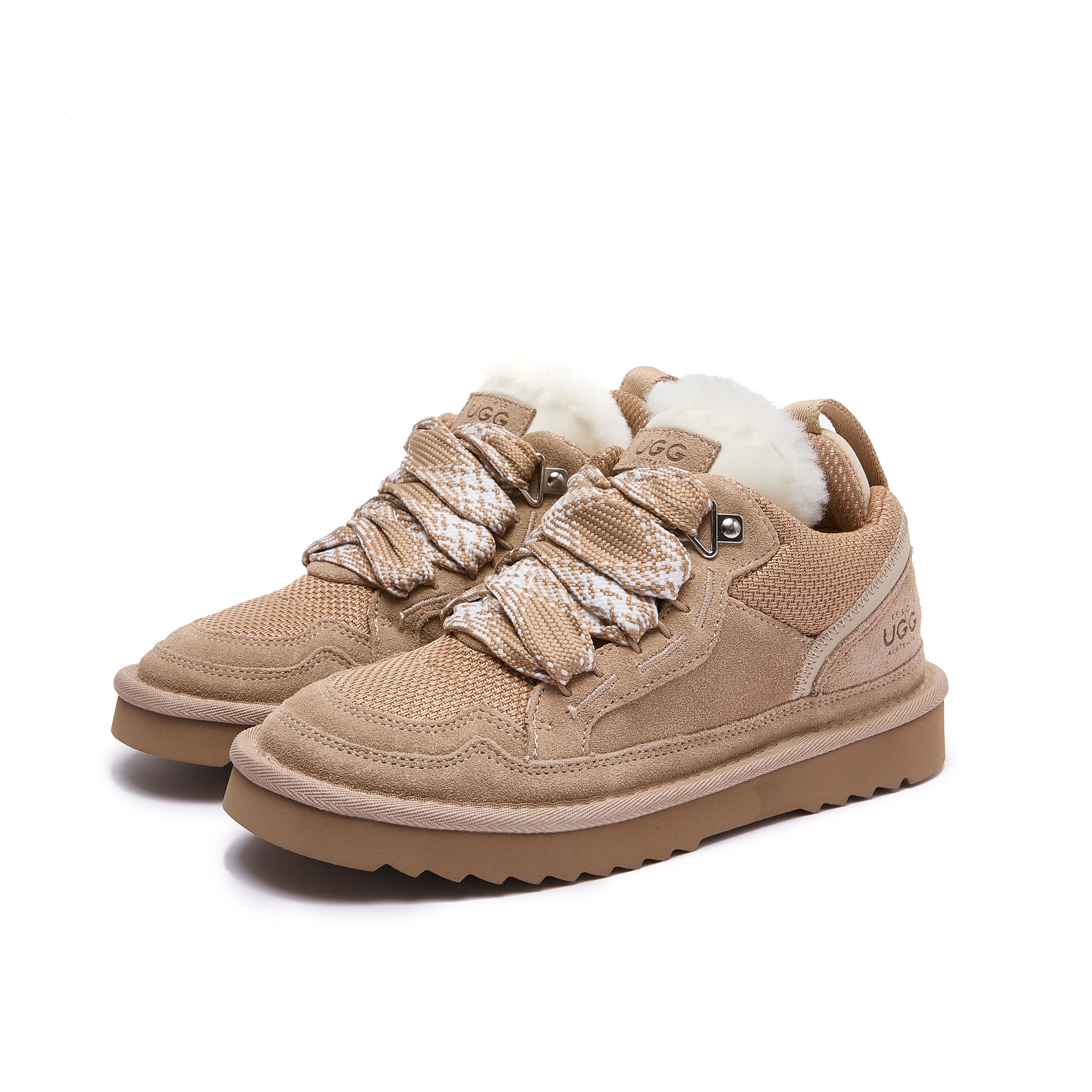 Leslie Chunky Sheepskin-Lined Sneaker in Sand - A pair of beige low-top winter sneakers with thick brown soles, chunky woven laces, and white wool lining visible at the collar, photographed on a clean white background.