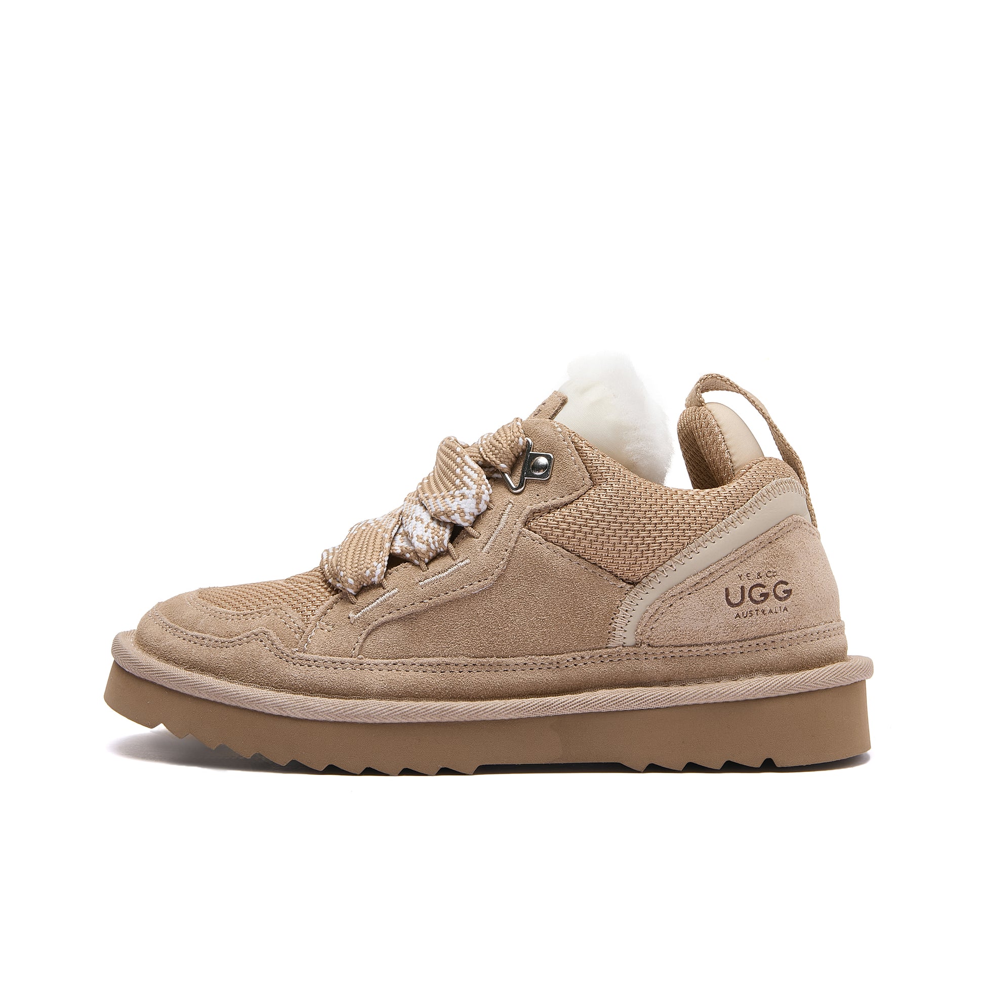 Leslie Chunky Sheepskin-Lined Sneaker in Sand - A single Ugg low-top sneaker in tan suede and mesh, featuring decorative braided laces, a white wool collar, and a thick tan sole, shown against a plain white background.
