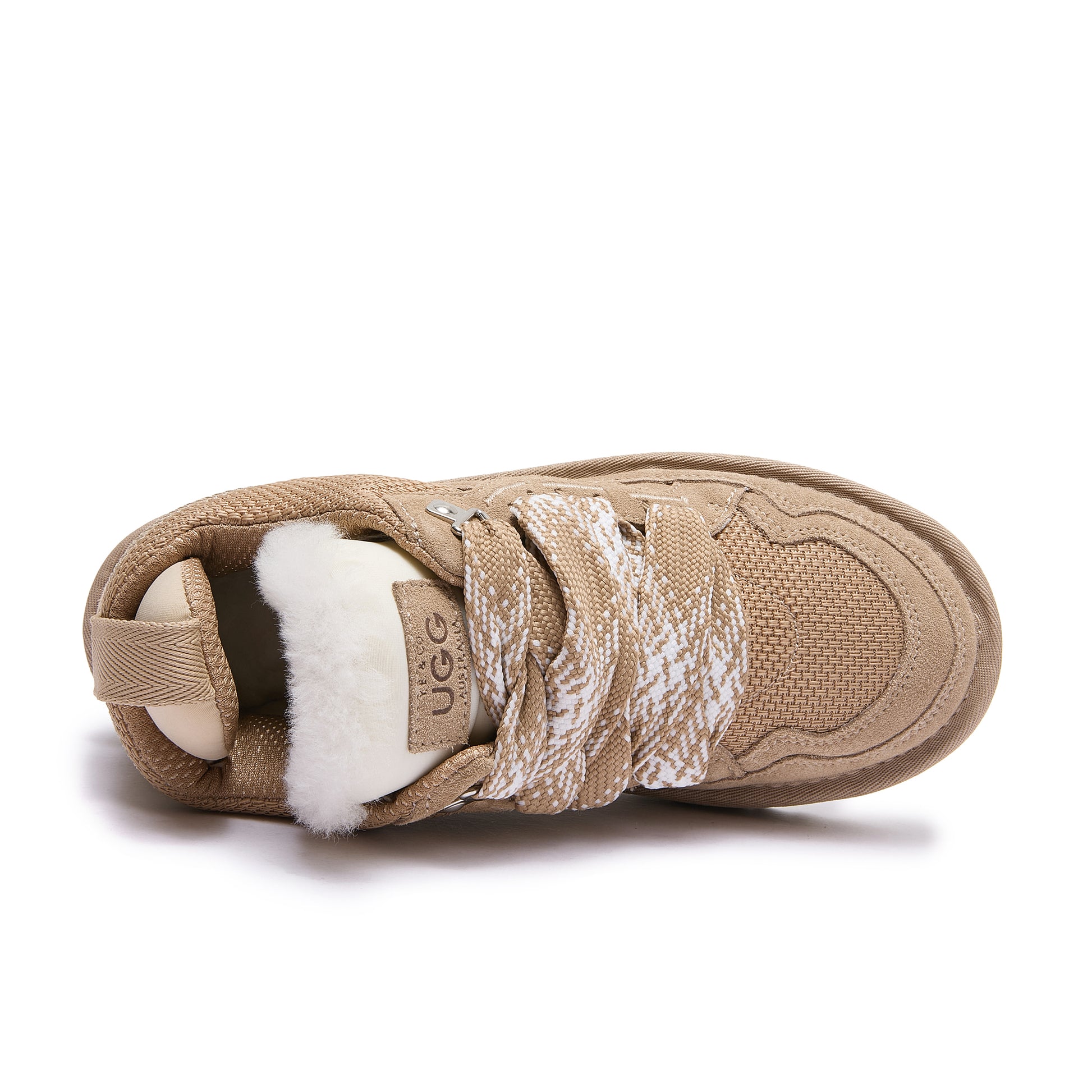 Leslie Chunky Sheepskin-Lined Sneaker in Sand - A single Ugg slip-on sneaker in beige canvas and suede with a white wool collar and patterned laces, shown from a side profile on a white background.