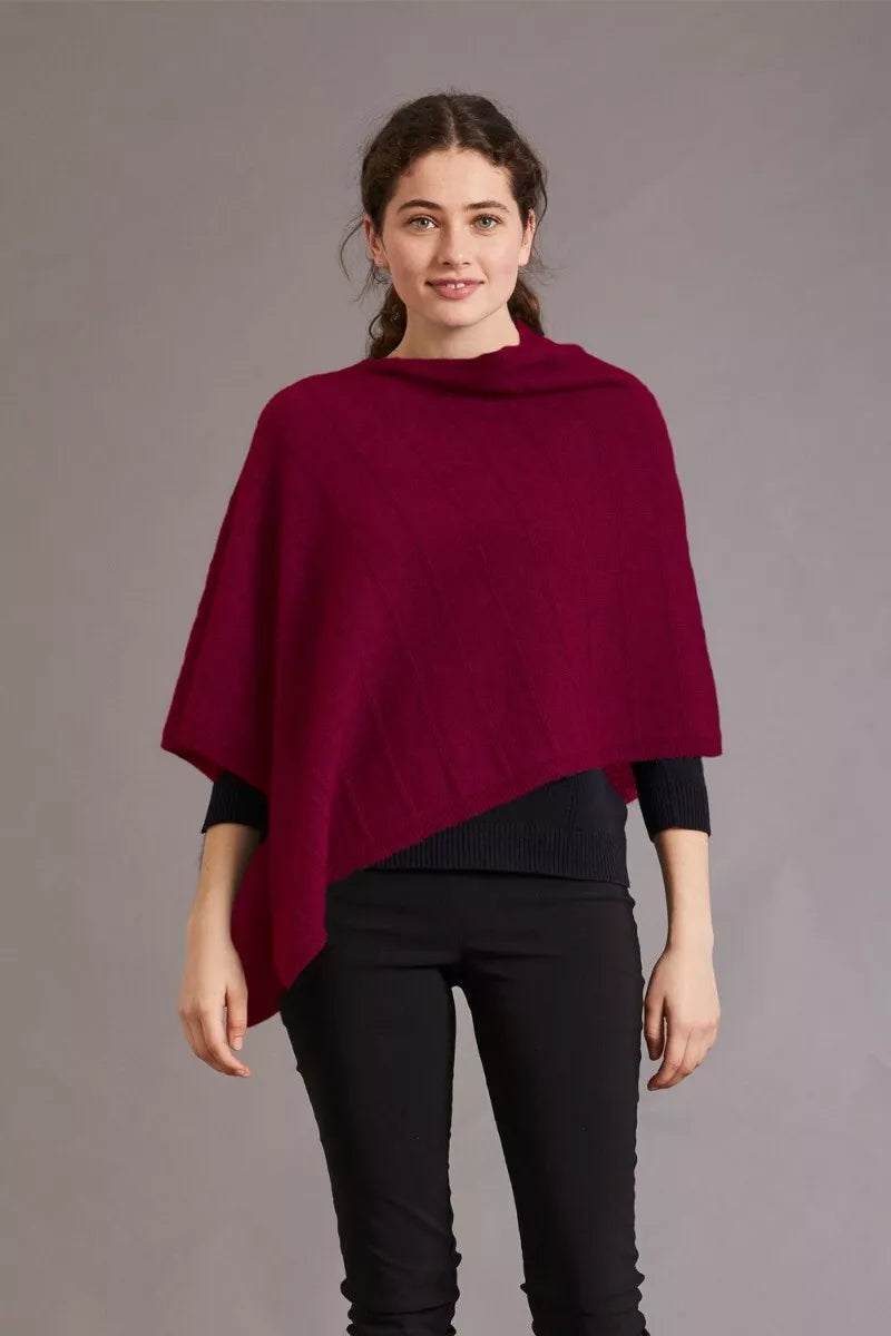 Burgundy wool poncho with draped asymmetrical design worn over black ribbed top, front view. - Yellow Earth Australia