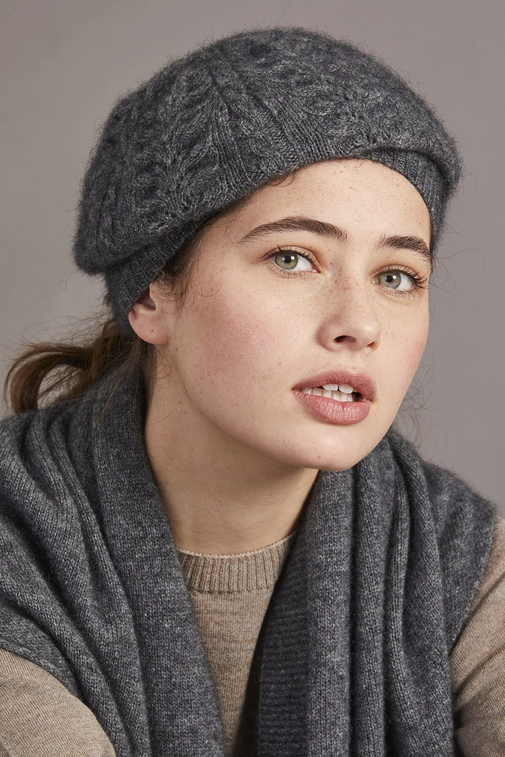 Grey wool beret with cable knit texture worn by model, side view. - Yellow Earth Australia
