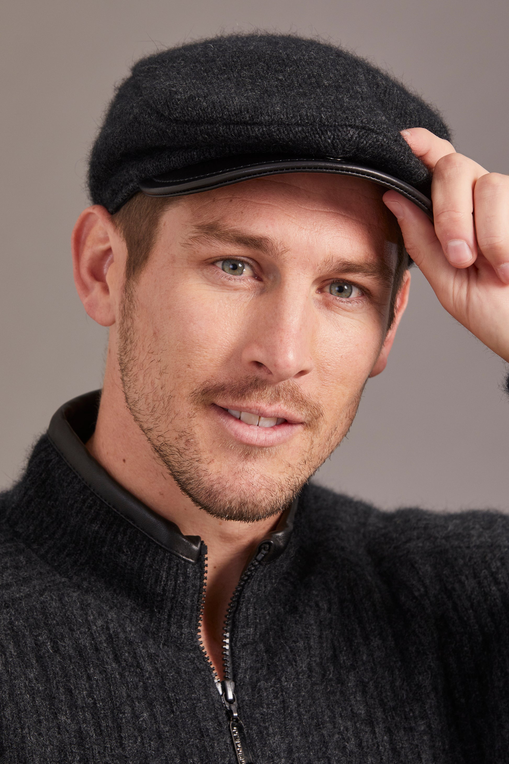Black wool flat cap with leather brim, front angled view on male model. - Yellow Earth Australia
