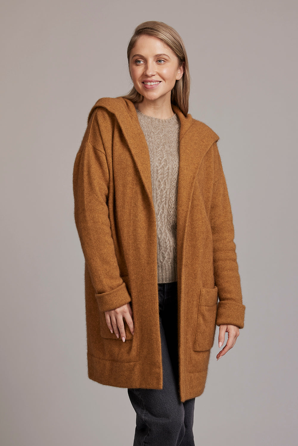 Woman wearing camel wool cardigan over grey knit, front view. - Yellow Earth Australia