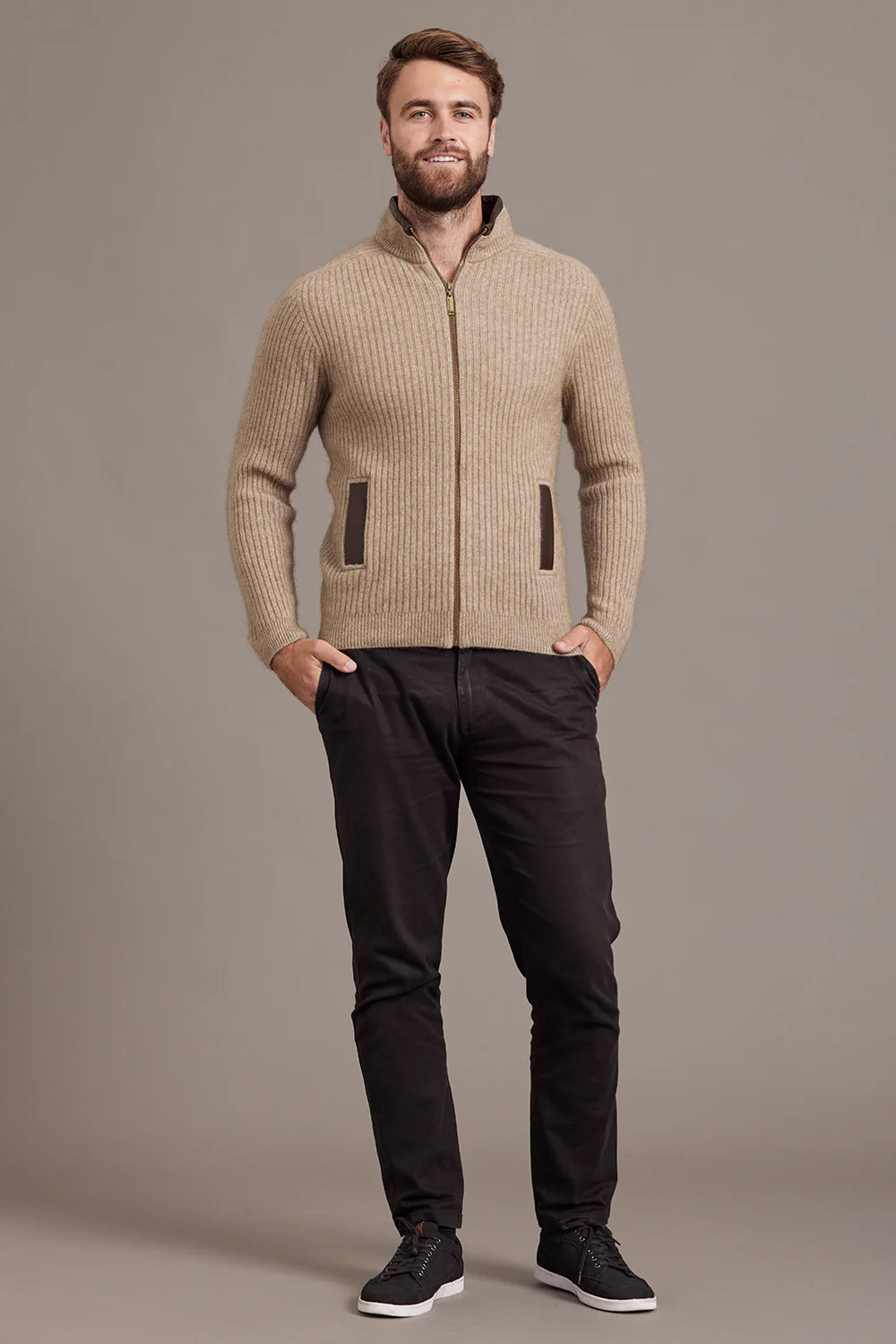 Beige ribbed wool zip-up cardigan with brown leather trim pockets, front view. - Yellow Earth Australia