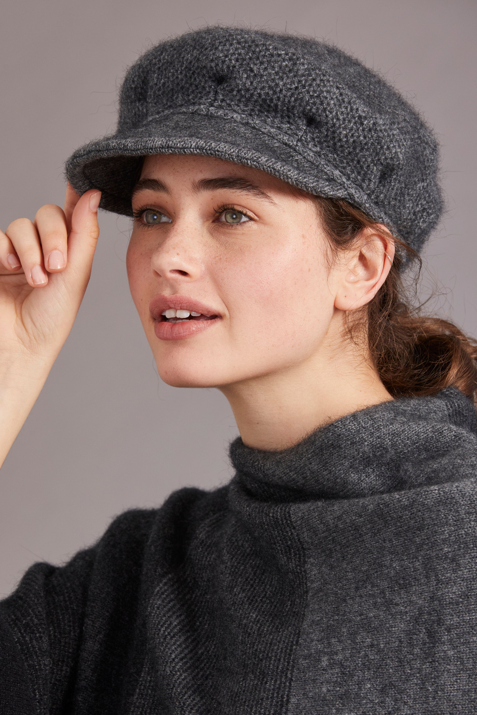 Grey wool newsboy cap worn by woman, side view showing soft knit texture and brim detail. - Yellow Earth Australia