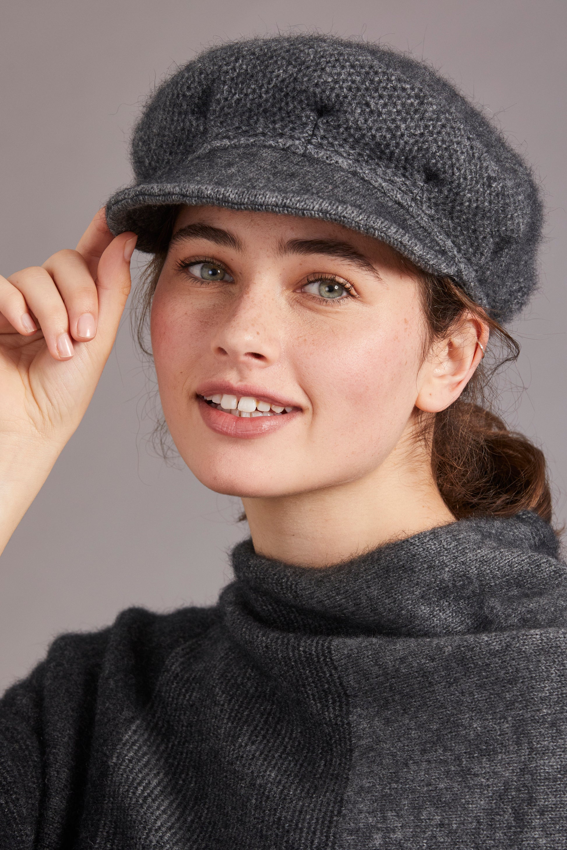 Grey wool newsboy cap with knit texture, worn tilted on model's head, side view. - Yellow Earth Australia