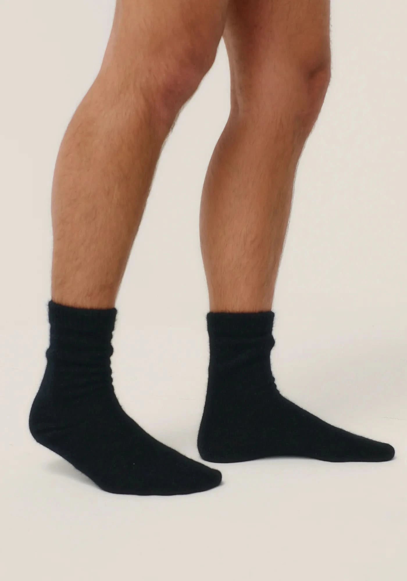 Black wool crew socks displayed on male feet against neutral background. - Yellow Earth Australia