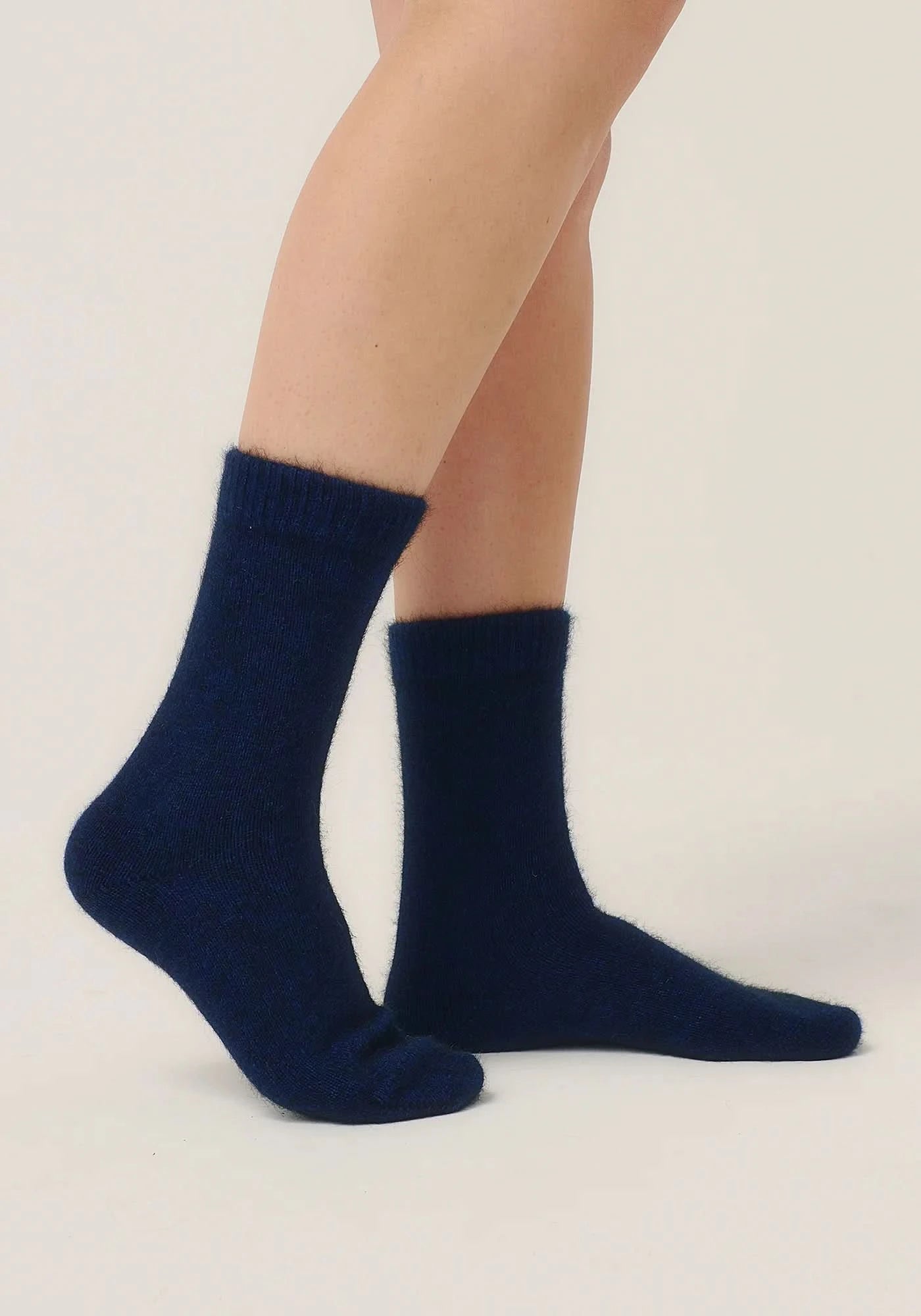 Navy wool socks with fluffy texture shown on feet against white background. - Yellow Earth Australia