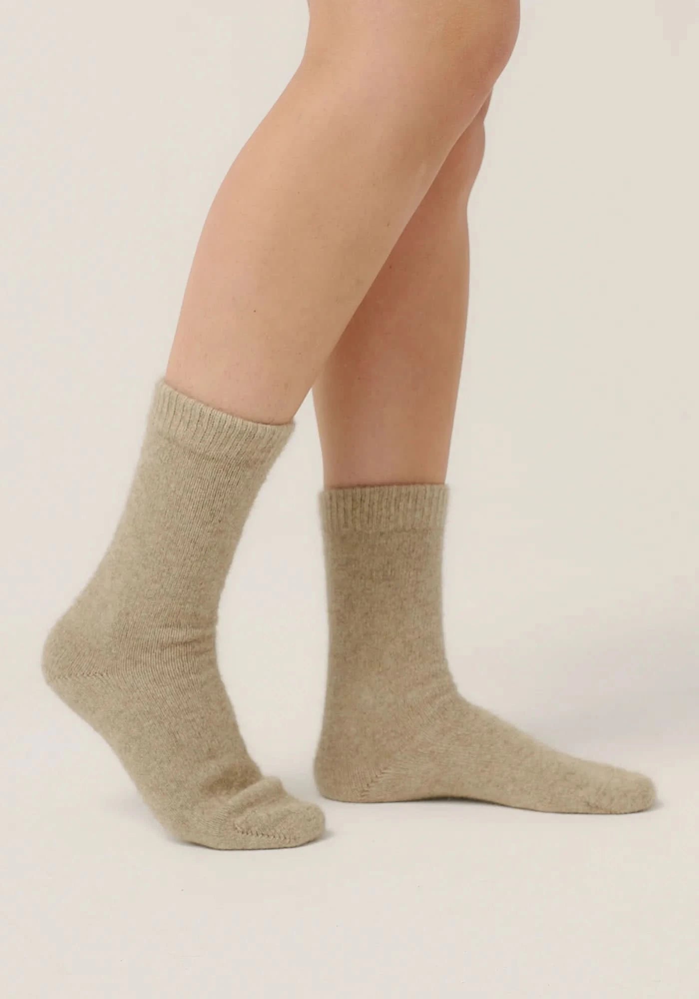 Beige wool crew socks displayed on legs, side view showing texture and fit. - Yellow Earth Australia