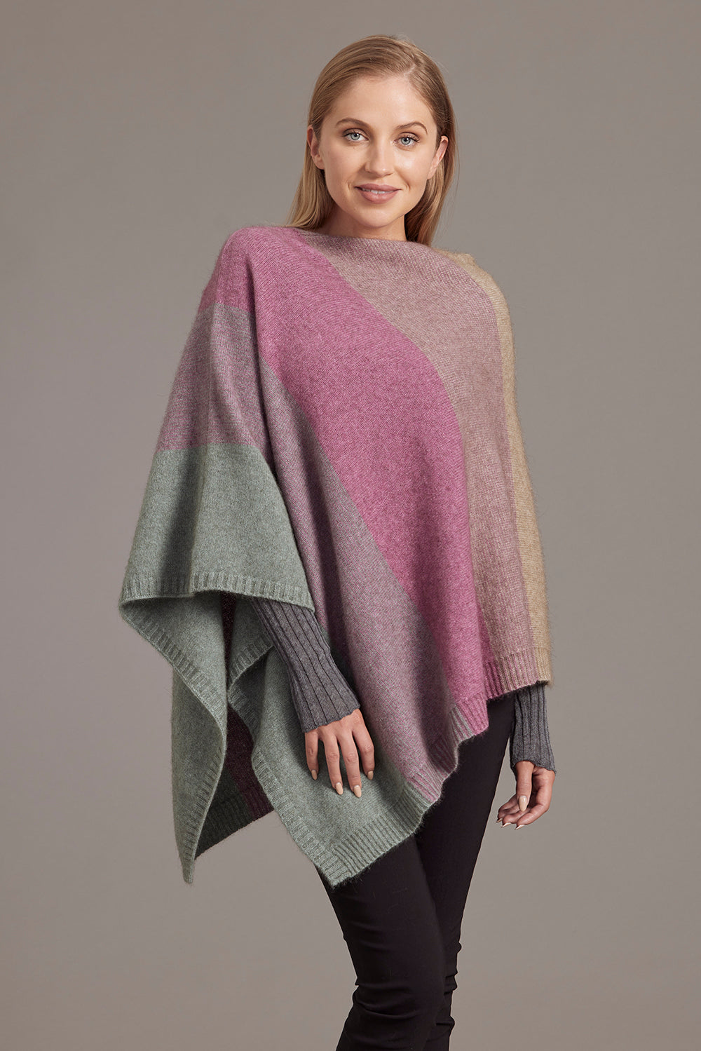 Colorblock knit poncho in pink, grey and green wool displayed on model against neutral background. - Yellow Earth Australia